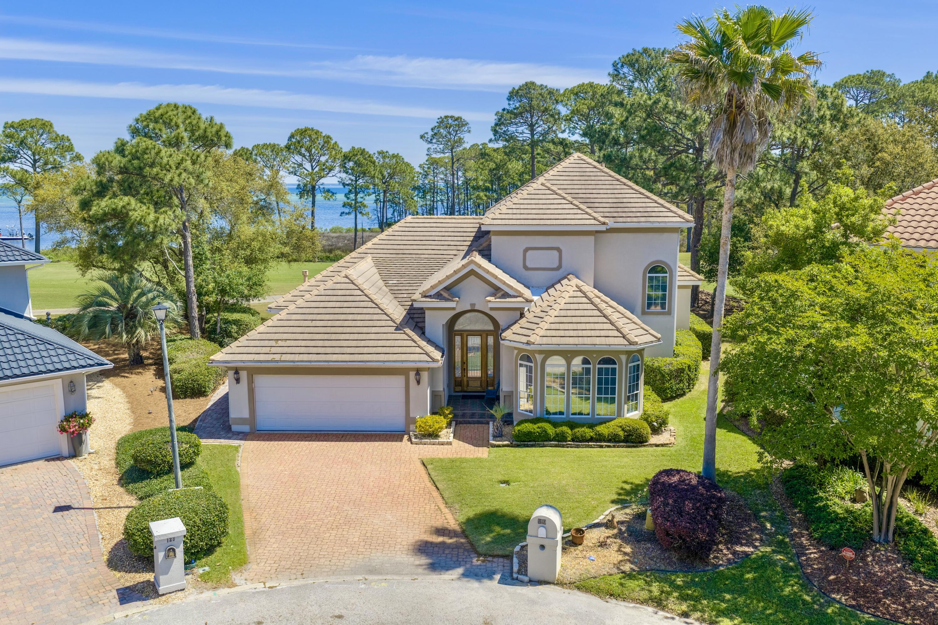 WHAT A VIEW! Catch your breath! The Choctawhatchee Bay, the Emerald Bay Golf Course and oh the sunset! This custom built one owner Bay Front home is on the 16th green and perfect for entertaining! Designed for your relaxed, elegant lifestyle! Soaring ceilings, crown molding and architectural details throughout! This house says QUALITY! Meticulously maintained and exquisitely appointed, this spacious home is ready to be enjoyed by you, your friends and family. Enter into the welcoming foyer and step into the expansive tiled great room with fireplace and wet bar. Enjoy sweeping golf course views from nearly every room, as the main living areas and primary suite open seamlessly to the outdoor space. No expense has been spared! The finishes in this home are first class and the space is very well utilized. Great storage, large living space & closets galore. The kitchen is as functional as it is inviting, with granite countertops, stainless steel appliances, a prep island, under-cabinet lighting, tiled backsplash, and custom cabinetry for storage.The en suite bath features a jetted tub, separate shower, dual vanities, a private water closet, and two closets, including a walk-in. Designed with everyday comfort in mind, the home also includes a laundry room and cabinetry. Truly move-in ready, this home offers a turn-key opportunity in one of the area's most sought-after communities. Located in an X flood zone with a low HOA, Emerald Bay provides access to golf, a clubhouse, tennis courts, and a community pool--all just minutes from shopping, dining, and the beach.