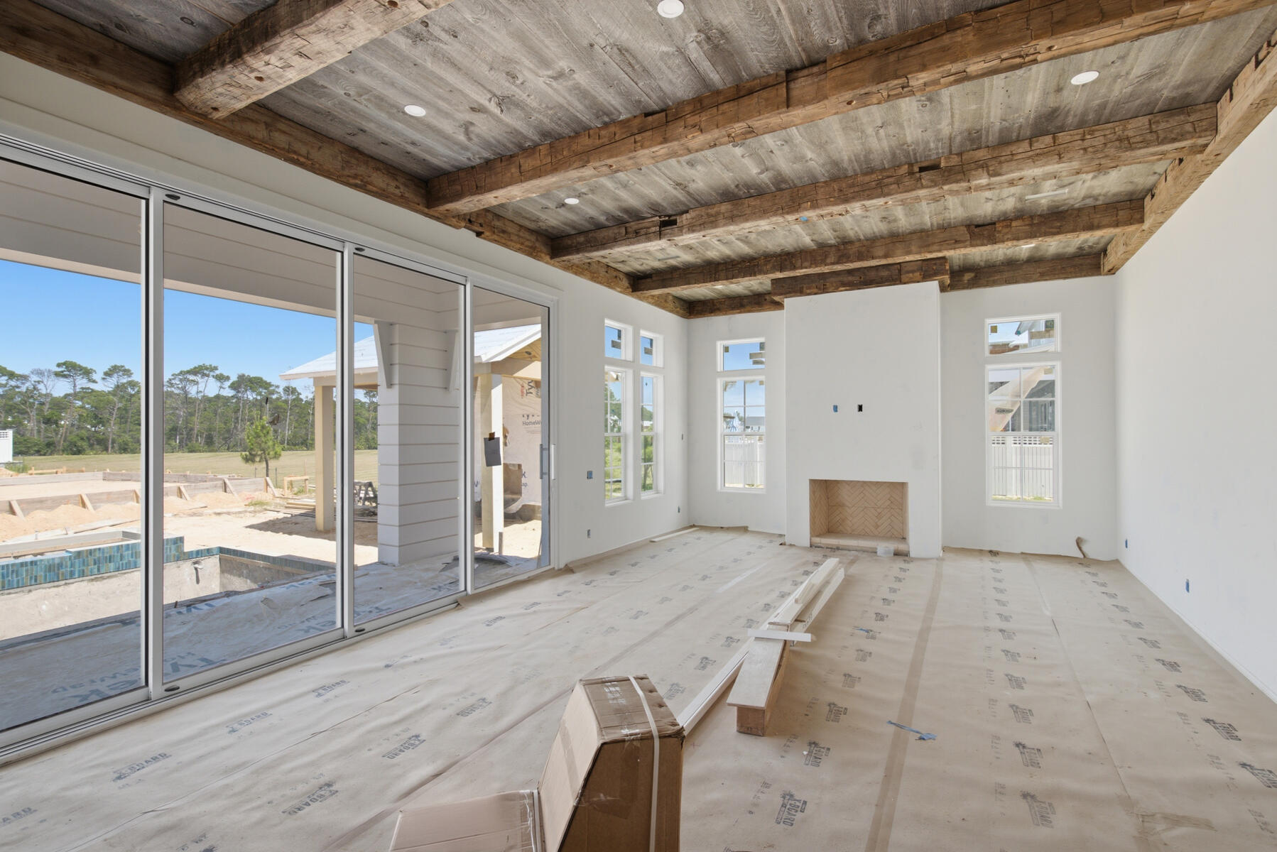 Crafted by Cole Construction, this newly envisioned retreat blends timeless architecture with modern livability. Featuring five bedrooms, five bathrooms, two half bathrooms in the main living area, and a detached one bedroom, one bathroom carriage house apartment above the expanded two car garage with designated area for a golf cart, this two-story coastal home offers over 4,300 square feet of conditioned living space.

The inviting entry opens into an airy, open-concept layout where the chef's kitchen, dining, and living areas flow seamlessly together. The Great Room features a gray barn wood ceiling accented by reclaimed 200-year-old hand-hewn beams. The kitchen showcases professional-grade appliances, a generous breakfast counter, custom cabinetry, a 48-inch gas range with vent hood and pot filler, a farmhouse sink, and abundant natural light. A separate chef's pantry adds additional prep space, while the living room centers on a direct-vent gas fireplace with custom built-ins.

The primary suite provides a serene first-floor retreat, with a freestanding soaking tub, dual vanities, an oversized walk-in shower, a substantial custom-fitted closet, and direct access to the covered porch and pool terrace, creating an effortless indoor-outdoor connection. A second bedroom on the first floor serves as an ideal guest suite with its own private bath.

Upstairs, three guest suites each with private bath and walk-in closet, surround a generous loft lounge, offering flexible living for family or guests. Covered porches extend from multiple rooms, capturing breezes and peaceful neighborhood views.

The outdoor living area is designed for year-round enjoyment with a saltwater pool featuring a sun shelf and integrated spa, a built-in fire pit, and a brick pavilion housing a complete summer kitchen with grill, sink, and beverage refrigerator. An outdoor shower and cabana bath add convenience for poolside entertaining.

A detached carriage house apartment above the expanded garage offers a kitchen with full-size appliances, vaulted living area with built-in bookshelves and a separate bedroom with a full bathroom, creating the ideal space for extended guests or private office retreat.

Exterior details such as board-and-batten and nickel-gap siding, decorative wood brackets, and architectural corbels highlight the home's craftsmanship and coastal character.

From its thoughtful layout to its refined finishes, this new Cole Construction home embodies the effortless charm and enduring quality of Watersound Origins living.

Estimated Completion: Nov. 2026