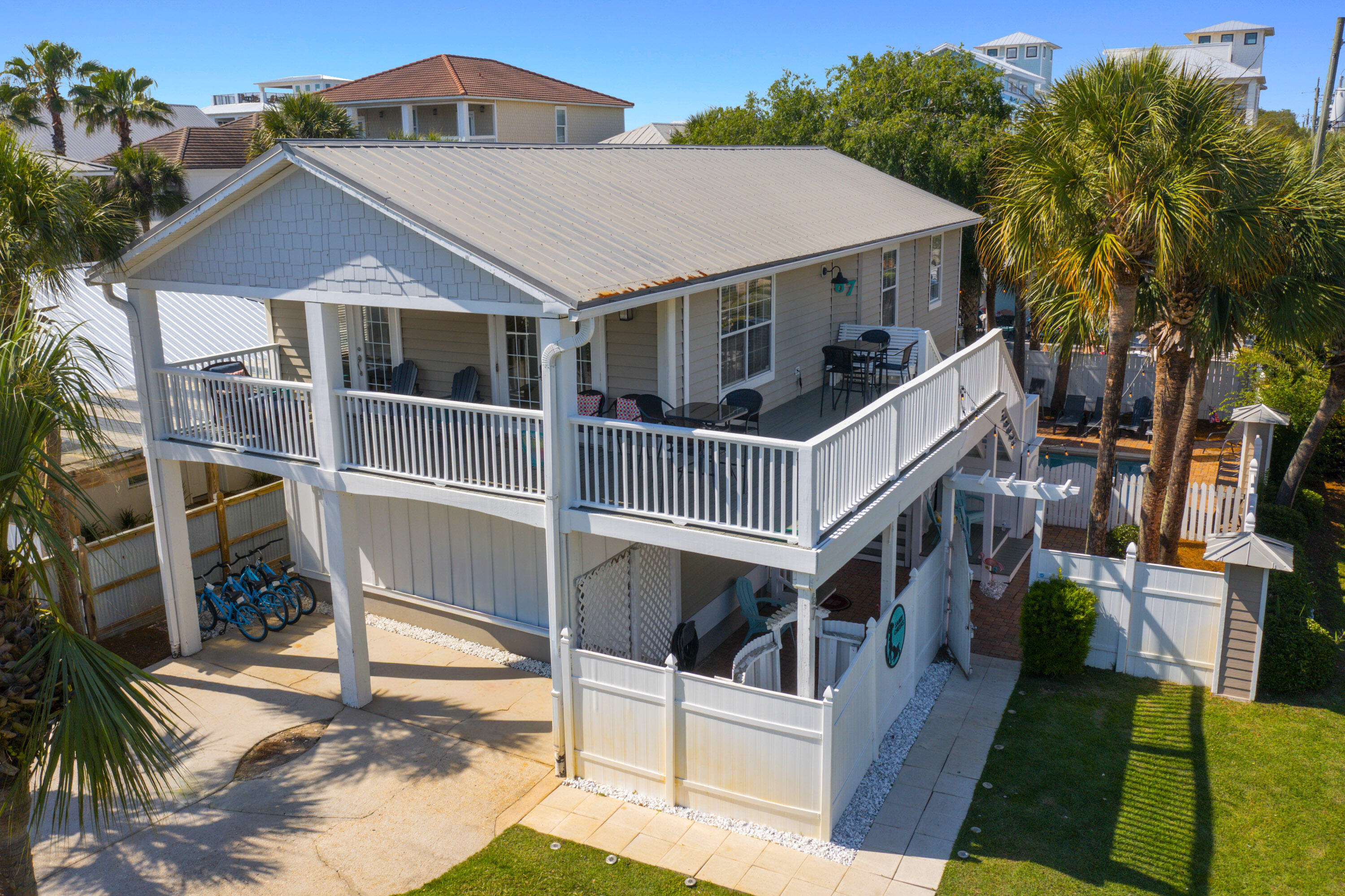 Elevated two-story income-generating property with two entirely independent, self-contained units, Private Pool & Expansive Wraparound Porches.The original upstairs built on stilts is a rare blend of history, craftsmanship, and coastal charm with wooden plank floors, a full-size dining area, updated kitchen with stainless-steel appliance, granite countertops, tumble-stone backsplash and a large pantry. The cozy vintage-style corner sofa was chosen for its' deep comfort and as a sandy-day hang-out spot with room for the whole family. Sleeping accommodation includes all NEW furnishings and bedding has a large Master bedroom, updated ensuite, twin-over-full bunk bedroom, updated full bath, washer and dryer.  Upstairs HVAC installed 05 28 2021 Water Heater 04 20 2010. The downstairs unit features a total, top-to-bottom remodel engineered and executed by licensed professionals, including a 18-inch elevation increase. Every component of this ground-floor space is completely brand new.  NEW Engineer designed Monolithic Concrete Slab, NEW High-end Poured terrazzo flooring, NEW cabinets, NEW appliances, NEW Impact rated door and repurposed windows, NEW bathrooms, NEW Electrical Panel and all new wiring, , NEW Water Heater 04 20 2025, HVAC 05 28 2022, NEW Furnishings, NEW! NEW! NEW!  This dual-occupancy layout offers distinct, self-contained units--complete with private entrances, kitchens, baths and washer/dryer. Sold Fully, NEWLY furnished, rental ready (accommodates 17 guest) NO HOA Enjoy your own private pool in a fenced-in oasis, complemented by beautifully appointed  lounging areas, with backyard grill and picnic table. Access the beach via the Hollywood gate where the glowing emerald green and aquamarie water and the powered sugar-white sand awaits.  Local Winery, eateries and shopping all within walking distance. Soak up the sunshine during the day and explore the large malls, theaters, entertainment and famous seafood restaurants within a two-to-five-mile driving distance any time you please.  All facts and measurements deemed to be accurate and should be verified to consumer satisfaction. This property is on the Vacation Rental Program with Ocean Reef Resorts. All future reservations must be honored with Ocean Reef.