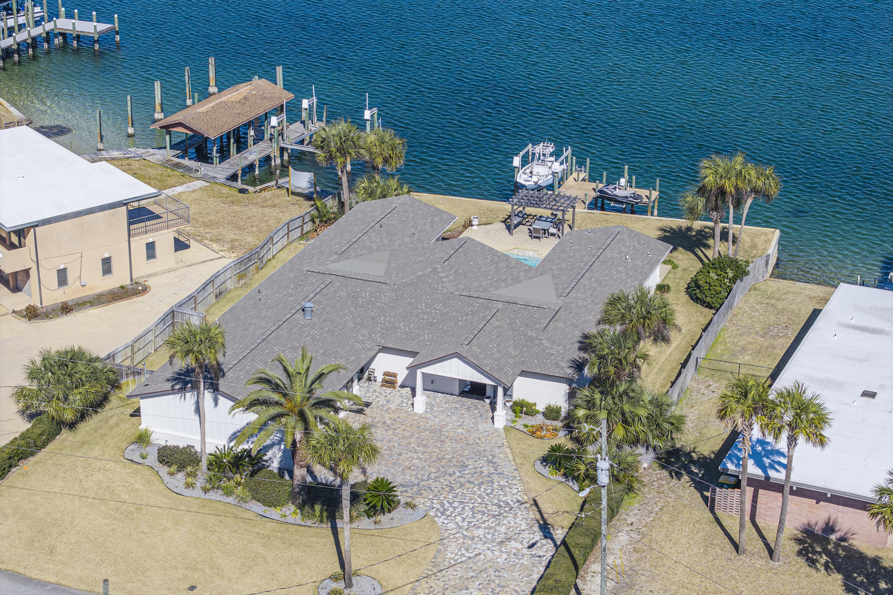 Stunning Newly Renovated Waterfront Coastal Retreat, Just Moments from the Beach!  Welcome to your slice of paradise, a beautifully reimagined 5-bed/4-full bath, single-family home spanning over 3200sf of sophisticated living space on a .32-acre lot with 100' waterfront in the highly desirable Okaloosa Island area.  This 1971 built home has been completely transformed with high-end renovations throughout, blending timeless coastal charm with contemporary luxury. Step inside to discover an open-concept floor plan bathed in natural light, featuring brand-new large format porcelain tile flooring, fresh neutral paint, smooth modern ceilings and trim, and elegant recessed lighting that creates an inviting, airy atmosphere perfect for relaxed Florida living or entertaining.  The gourmet kitchen is a chef's dream, boasting quartz countertops, matching solid quartz backsplash, stainless steel appliances, a large waterfall center island with breakfast bar seating, custom soft-close cabinetry, ideal for preparing meals while staying connected to family and guests in the adjoining living and dining areas.
The Waterfront Dining Room is perfect for entertaining. This space boasts the ability to seat 30 guests at one time, with a custom-made natural wood dining table. The wet bar sits on one side of the room with antique glass backsplash, an icemaker, and large wine cooler, while the adjacent side has a custom banquet booth for additional seating.  All 5 generous bedrooms offer ample space and comfort with access to the pool from every bedroom. The primary suite provides a peaceful retreat complete with a spa-like en-suite bathroom featuring modern fixtures, a walk-in shower, luxurious soaking tub, dual vanities, and plenty of storage. A newly built guest suite with its own private bathroom. Two bedrooms that share newly renovated jack and jill bathroom have been fully updated with contemporary tile work, new vanities, and high-efficiency fixtures.  Additional highlights include:
·Brand-new roof, HVAC system, plumbing, and electrical updates for peace of mind.  ·Brand new extra deep Double Car Garage for two large cars and more storage.  ·Expansive living areas with flexible bonus spaces (perfect for a home office, media room, or guest suite potential).  ·Large, fenced backyard with a pool, and outdoor teak dining and lounging areas for endless coastal entertaining.  ·Ample parking and storage options.  ·No HOA restrictions in this sought-after neighborhood.  Location is everything here - you're just a short 3 min stroll (500 ft.) from the sugar-white sands and emerald waters of the Gulf of Mexico. Enjoy full Choctawhatchee Bay access with a deep-water dock with both boat & wave runner lifts. Just out the backdoor you will have access to the Florida Intercoastal Waterway, Crab Island and the Gulf of Mexico, for fishing, water sports, and the vibrant dining/shopping scene of Fort Walton Beach and Destin. This prime spot offers the best of Emerald Coast living; beach proximity without the high-rise condo fees!  Whether you're seeking a primary residence, vacation getaway, or smart investment property in one of Florida's most coveted coastal markets, this turnkey renovated beauty is move-in ready and waiting for its new owners.  Don't miss this rare opportunity - schedule your private showing today and start living the beach life you've always dreamed of!