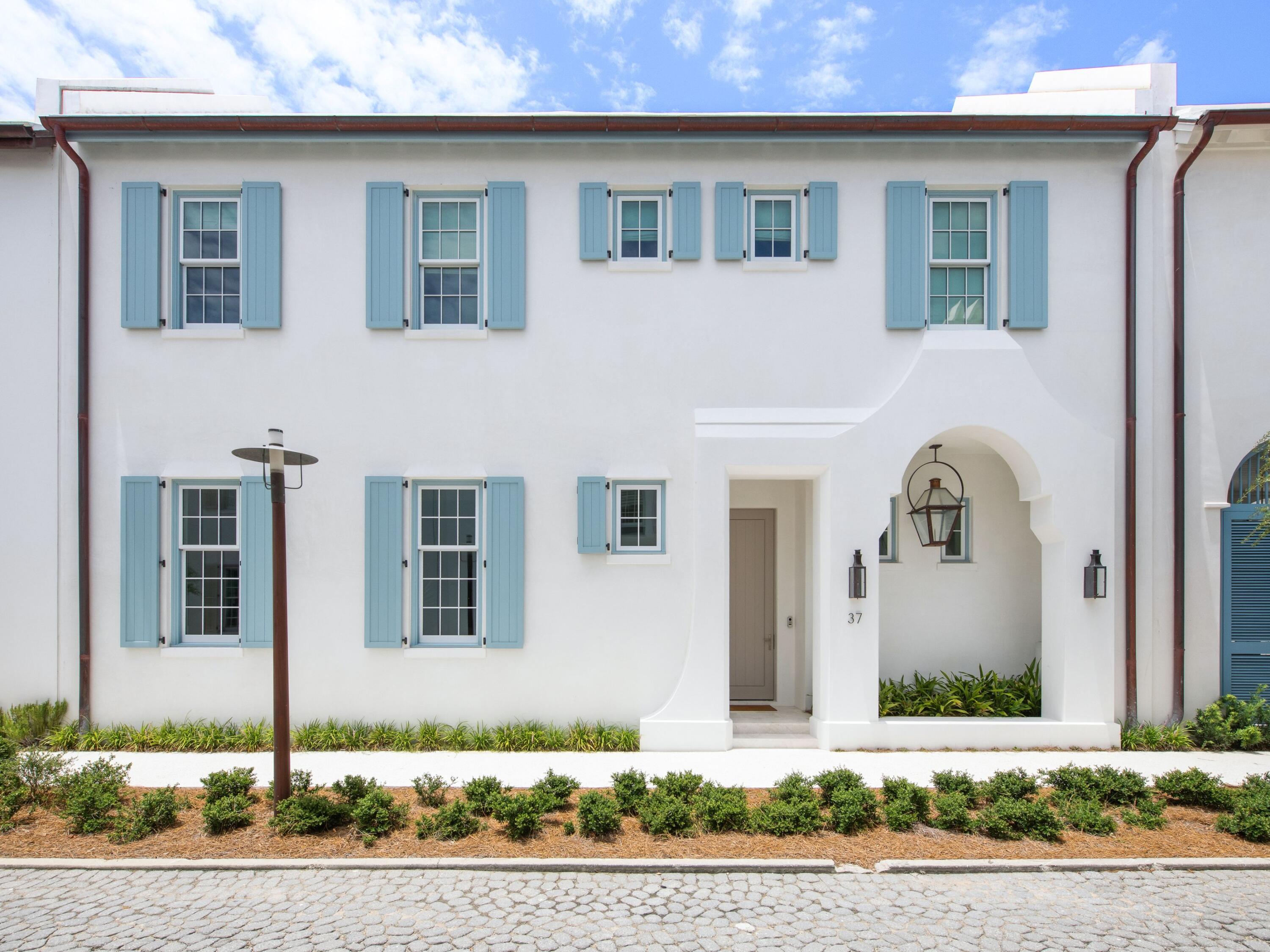 Completed in 2025 and ideally positioned just steps from the iconic Caliza Pool and Zuma Fitness and Wellness Center, 37 Caliza Lane offers the rare opportunity to own a nearly new, never-rented residence in one of Alys Beach's most amenity-rich locations. Spanning 3,421 square feet, the five-bedroom, five-and-a-half-bath residence--including an attached carriage house--is designed with an emphasis on light, scale and effortless indoor-outdoor living. Soaring 12-foot ceilings, Venetian plaster walls and marble flooring define the main level, while designer lighting, tall windows and French doors add warmth and natural light throughout. The spacious kitchen features a large center island, extensive custom cabinetry, marble surfaces and a premium Sub-Zero and Wolf appliance package. The first-floor primary suite offers privacy and convenience, while all five bedrooms are ensuite and feature built-in closets. Upstairs, wide-plank wood flooring and beautifully appointed marble baths continue the home's refined aesthetic. Two laundry areas add convenience, and an integrated audio/visual system extends throughout the home and rear porches.  Designed as an extension of the interiors, the generous courtyard features mature landscaping, a wood-burning fireplace, built-in grilling and rotisserie area, and multiple covered and open-air spaces for gathering and relaxing. The attached carriage house has a private bedroom and bath, living area and kitchenette--an ideal retreat for extended family or guests. Additional features include an elevator, garage and covered carport. Lightly used and exceptionally maintained, 37 Caliza Lane presents a rare opportunity to enjoy a beautifully finished, nearly new home in the heart of Alys Beach without the time and complexity of building.