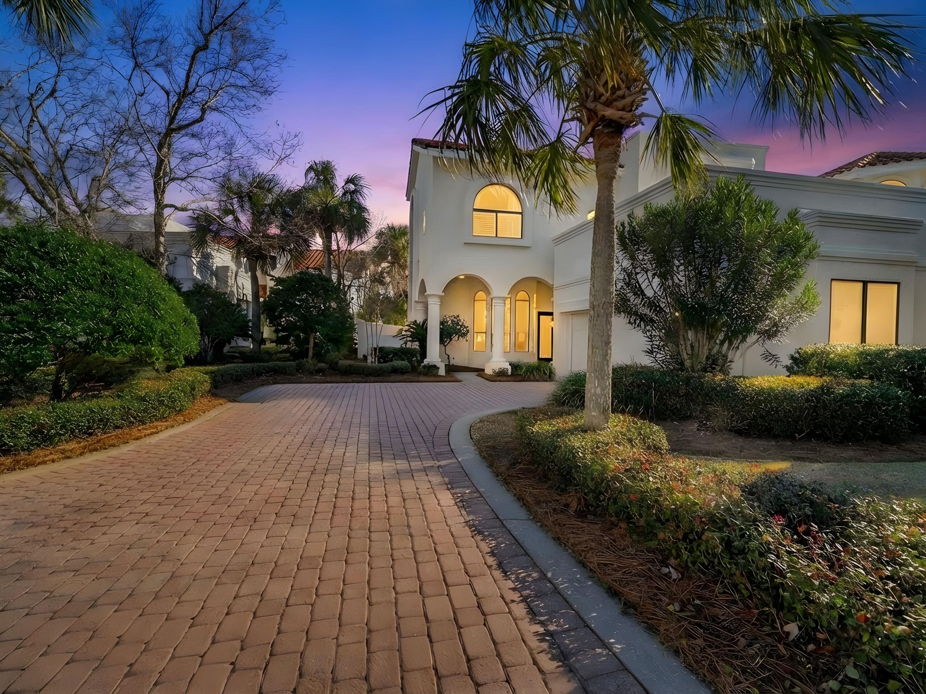 Perfectly positioned behind the gates of a sought-after resort enclave, this remodeled villa pairs privacy with a front-row seat to one of the area's most vibrant lifestyle hubs. Set along the eighth fairway of Baytowne Golf Course, the residence overlooks a tranquil lake accented by four illuminated fountains just beyond the patio. Evenings arrive with a flourish as fireworks light the sky, visible from your own outdoor retreat. Inside, soaring ceilings and a dramatic entry create an immediate sense of scale, while expansive windows frame golf course and water views. The open entertaining area flows seamlessly into a thoughtfully updated kitchen appointed with granite countertops, new flooring, and a suite of top-tier appliances, including a Dacor oven and microwave, gas cooktop, Bosch  dishwasher, and KitchenAid refrigerator. Whether hosting friends or enjoying a quiet night in, the space balances sophistication with comfort. A gas fireplace anchors the living area, adding warmth and architectural interest. The upstairs laundry enhances everyday convenience, while the spacious primary suite offers a large bath with a separate soaking tub and shower for a spa-like experience. An oversized two-car garage provides ample storage and room for a golf cart, making it easy to take advantage of the resort's extensive amenities. Patio spaces extend the living area outdoors, inviting al fresco dining, morning coffee beside the fountains, or an afternoon spent watching golfers pass by. For those who enjoy a leisurely pastime, "catch and release" fishing is just steps away. Beyond the villa, a lifestyle of ease unfolds. A quick golf cart ride through the underground tunnel leads to the beach. Four championship golf courses, tennis facilities, a marina and the lively shops and restaurants of Baytowne Wharf are within walking distance. Grand Boulevard's boutiques, dining and entertainment options are equally convenient, placing the best of the resort experience right at your doorstep. With its remodeled interiors, exceptional location and captivating views, this villa offers an elevated coastal retreat designed for both relaxation and refined entertaining.