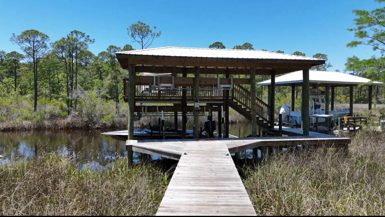 Bring your boat and live the waterfront lifestyle most buyers spend years trying to find -- this rare bayou-front property is one of only 7 homes in the neighborhood with direct deep-water access to the bay. Located just 5.5 miles from Seaside and the beaches of 30A, 233 Maddox Street offers the perfect blend of boating, privacy, and coastal living in a quiet non-rental community.

The centerpiece of the property is the newly constructed $180,000 custom double-stall boathouse featuring two lifts, covered slips, a spacious upper-level sundeck, and easy access out to the bay for fishing, cruising, waterfront dining, and sunset rides. Whether you're an avid boater or simply want to enjoy life on the water, this setup is exceptionally hard to find in this price range and location.

Inside, the home has undergone approximately $300,000 in upgrades and improvements, including custom shelves and storage in the master closet, and a custom multi head steam shower, creating a move-in-ready coastal retreat designed for both everyday living and entertaining. The property offers the rare opportunity to enjoy a true waterfront lifestyle without the short-term rental traffic common in many nearby beach communities.

If you've been searching for a home that delivers boating convenience, privacy, proximity to 30A, and beautifully updated, this is a unique opportunity to own one of the area's most distinctive waterfront properties.