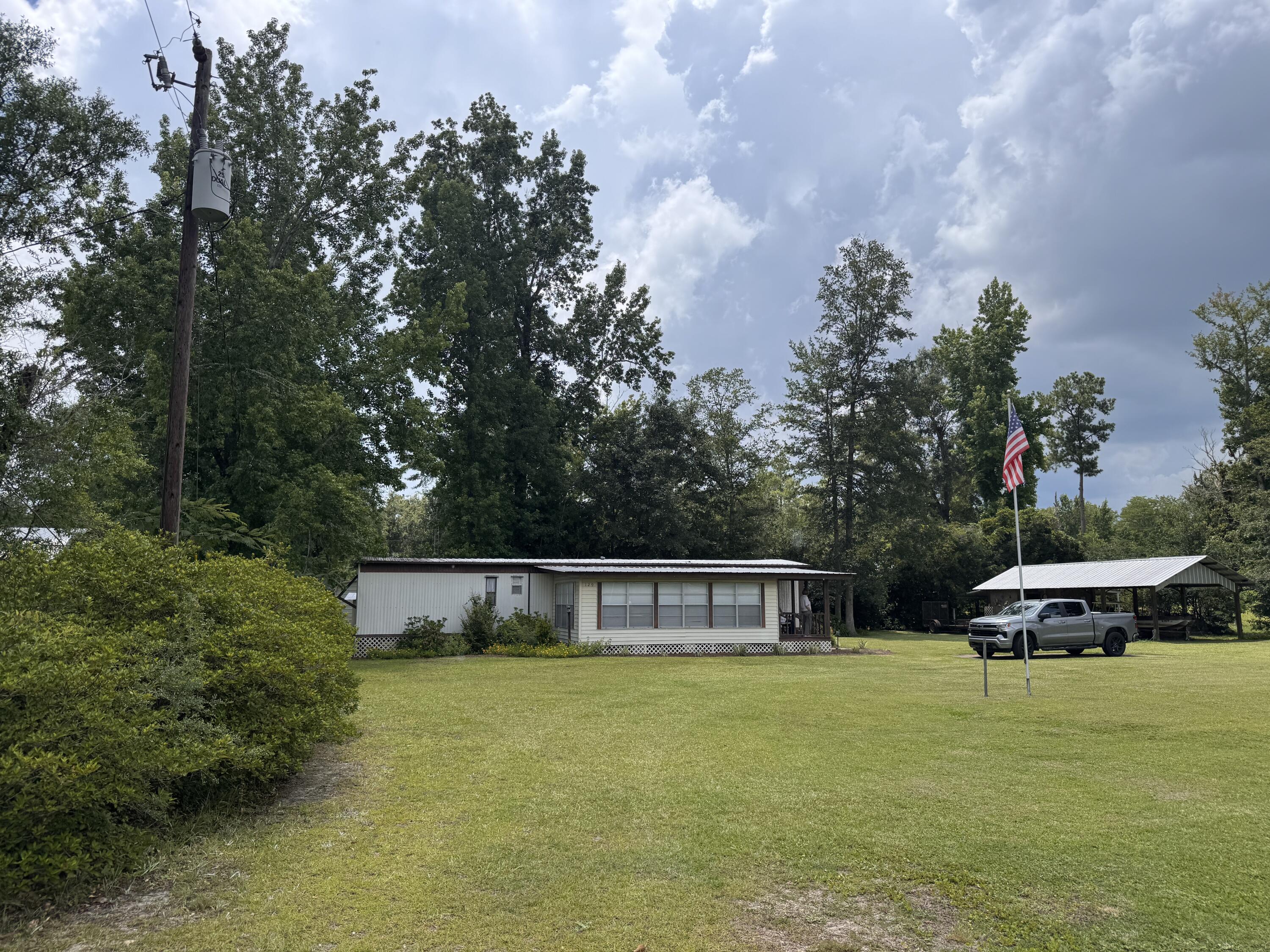 Move right into this immaculately maintained 1980 mobile home situated on a spacious lot in the heart of Wewahitchka! This well-cared-for home features updated flooring, a welcoming back porch, and a large heated and cooled sunroom that provides additional year-round living space. Whether you're looking for a full-time residence, weekend getaway, or the perfect fish camp, this property is ready to enjoy from day one. Outside, you'll find a pole barn with a covered fish cleaning station and power to charge your boat, making it ideal for anglers and outdoor enthusiasts. A private well and septic system service the home, and all furnishings and contents, excluding personal items, will convey, offering a truly turnkey opportunity. Located approximately 5 miles from the Dead Lakes County Park Boat Ramp, you'll have quick access to some of North Florida's best fishing and boating. Plus, you're only about 20 miles from Port St. Joe, where you can enjoy beautiful Gulf beaches, restaurants, shopping, and entertainment. Buyer should verify all measurements and information deemed important.