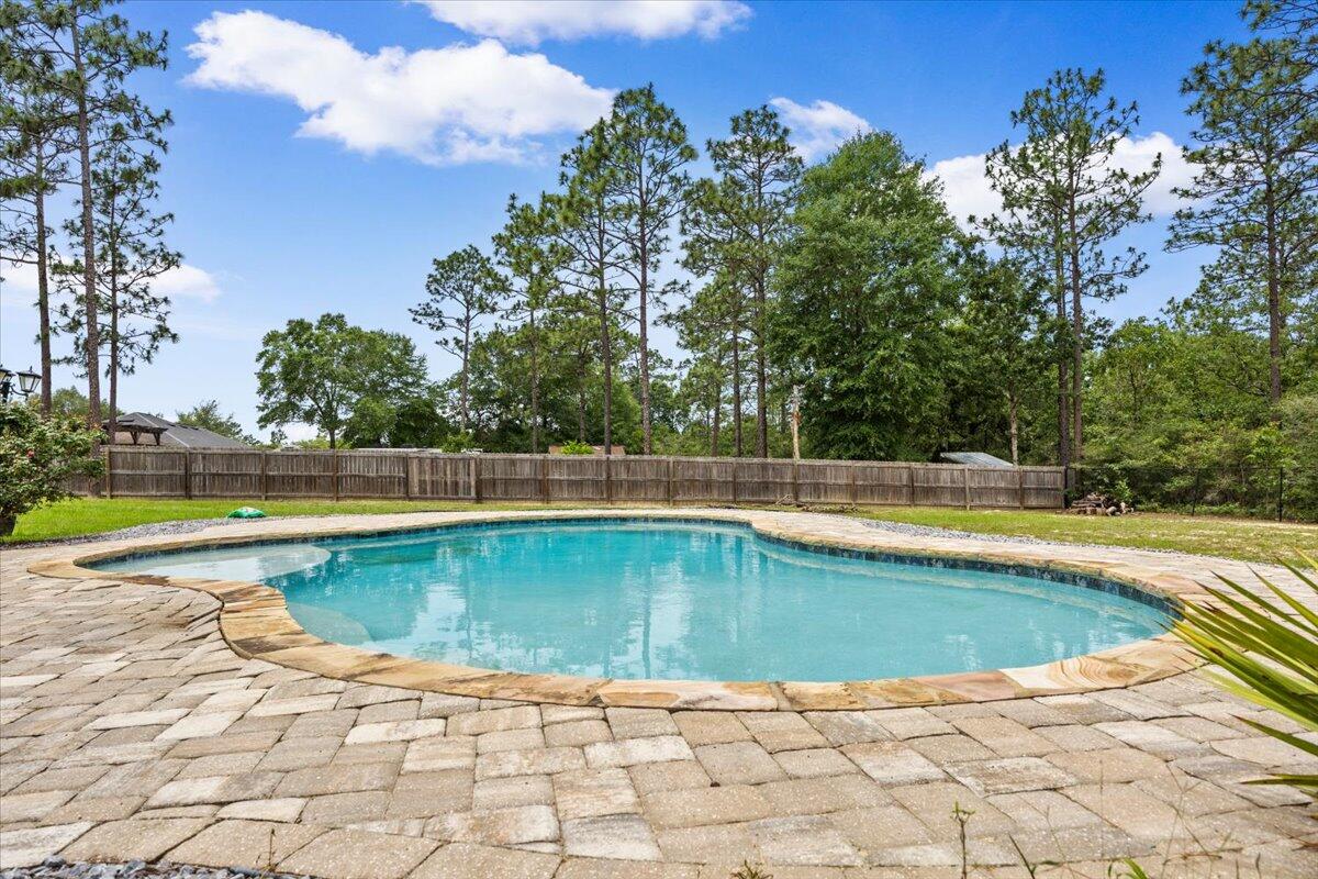 POOL HOME ON OVER AN ACRE IN YELLOW RIVER PLANTATION!
Experience the perfect blend of peaceful country living and modern convenience in this spacious custom-built home situated on over an acre in the highly desirable Yellow River Plantation community of Laurel Hill, Florida. Offering exceptional value and endless potential, this 4-bedroom, 3-bathroom home features a versatile floor plan designed for today's lifestyle.
Inside, you'll find a dedicated home office, formal dining room or flex space, spacious living room, and a separate den featuring a custom barn door entry--ideal for a media room, playroom, or additional living space. The oversized primary suite and generously sized secondary bedrooms offer abundant closet space, while the Jack-and-Jill bathroom layout provides separate vanity and shower areas for added functionality.
The heart of the home is the expansive kitchen featuring granite countertops, extensive cabinet storage, a large center island with electrical outlets, breakfast bar seating, built-in desk area, and an oversized walk-in pantry. The adjoining living area showcases a gas fireplace with custom built-ins, creating a warm and inviting gathering space.
Step outside and enjoy your private backyard retreat complete with a sparkling pool, updated gazebo, fully fenced backyard, and plenty of room to relax, entertain, garden, or enjoy the outdoors. The oversized driveway accommodates approximately 10 vehicles, offering plenty of parking for guests, recreational vehicles, boats, or additional family vehicles.
Additional upgrades include gutters, a security system, custom built-ins, updated lighting fixtures, kitchen pendant lighting, and updated ceiling fans in the living room, dining room, and primary suite.
Yellow River Plantation offers residents the charm of a custom-home community with the tranquility of country living. Neighborhood amenities include two stocked fishing ponds, two scenic nature trails, and a community playground. Enjoy the space and privacy of acreage living while remaining conveniently located near shopping, dining, schools, and major commuting routes throughout Northwest Florida.
This location is especially attractive for military personnel, offering convenient access to Eglin Air Force Base, Duke Field, Hurlburt Field, 7th Special Forces Group, and other military installations throughout the Florida Panhandle. Whether you're searching for a military relocation home, a pool home with land, or a spacious Northwest Florida property with room to grow, this home checks all the boxes.
Being sold AS-IS (new flooring, paint & minor cosmetic touch-ups needed), this property presents an outstanding opportunity to own one of the best values currently available in Yellow River Plantation. Come discover the lifestyle, space, and potential that make this community one of Northwest Florida's hidden gems.