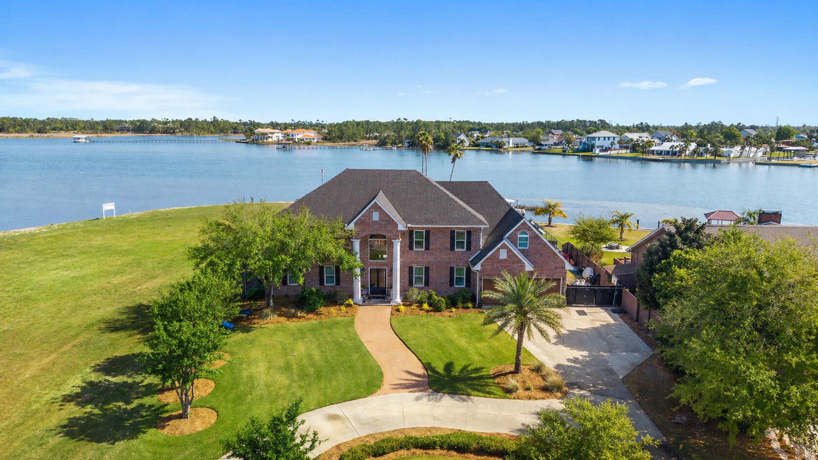 Coastal living at its finest! Discover your WATERFRONT slice of paradise in the heart of Lynn Haven, Florida, where everyday living feels like a permanent vacation. 

This stunning 2-story, 5-bedroom, 6-bathroom home with NO HOA features 5,575 square feet, a private pool and with pure Bay views, it offers the perfect blend of Florida charm and modern comfort, just minutes from pristine beaches and world-class fishing out your back door. Where privacy meets paradise, this bayfront estate is nestled on a quiet cul-de-sac with 130' water frontage on Upper Goose Bayou. 

This magnificent home sits on an expansive .79-acre homesite featuring your own private beach area and boat dock, with an additional dock currently in development. Wake up each morning in the luxurious main-level primary suite to breathtaking water views and the sea breezes from your covered back porch. You're going to love the oversized bedrooms, walk-in closets and high ceilings in this home! This estate also features a large bonus/flex room centered in the middle of the bedrooms upstairs as well as a very large flex bonus room which is great for an additional game room, storage for holiday items or even an additional bedroom, if needed. 

The upstairs is complete with a kitchenette and laundry for easy access and entertaining, as well. A home office is on the main level and just across from the primary suite giving easy access to pop in to work when needed in early hours or late evenings without interrupting the family. The family room flows on the main floor flows seamlessly from the foyer and provides extra-large picture windows and French doors with views to the Bay. The formal dining room sets the stage for holiday gatherings and separation when needed while providing additional seating for daily use. The kitchen is a showpiece blending a transitional feel with beautiful light cabinetry, a walk-in pantry, an island overlooking the pool and Bay and an abundance of cabinetry. 

Picture living in your own personal resort with this oversized estate homesite and dive into your private pool after a day of boating or fishing, or cast a line right from your backyard dock. The gorgeous brickwork adds timeless elegance to this coastal retreat, where every detail speaks to quality craftsmanship with a fireplace and multiple seating areas to gather. 

If you're looking for a family home for generations to come, this one checks all the boxes. Room for your family to grow, room for your family to host and room to truly LIVE the coastal waterfront lifestyle you've dreamed about! Just outside of Panama City, Lynn Haven's vibrant community offers small-town charm with big-city amenities, from waterfront dining to family festivals. 

With top-rated schools nearby and Panama City Beach's sugar-white sands just moments away, this isn't just a home, it's your gateway to the ultimate Florida lifestyle.