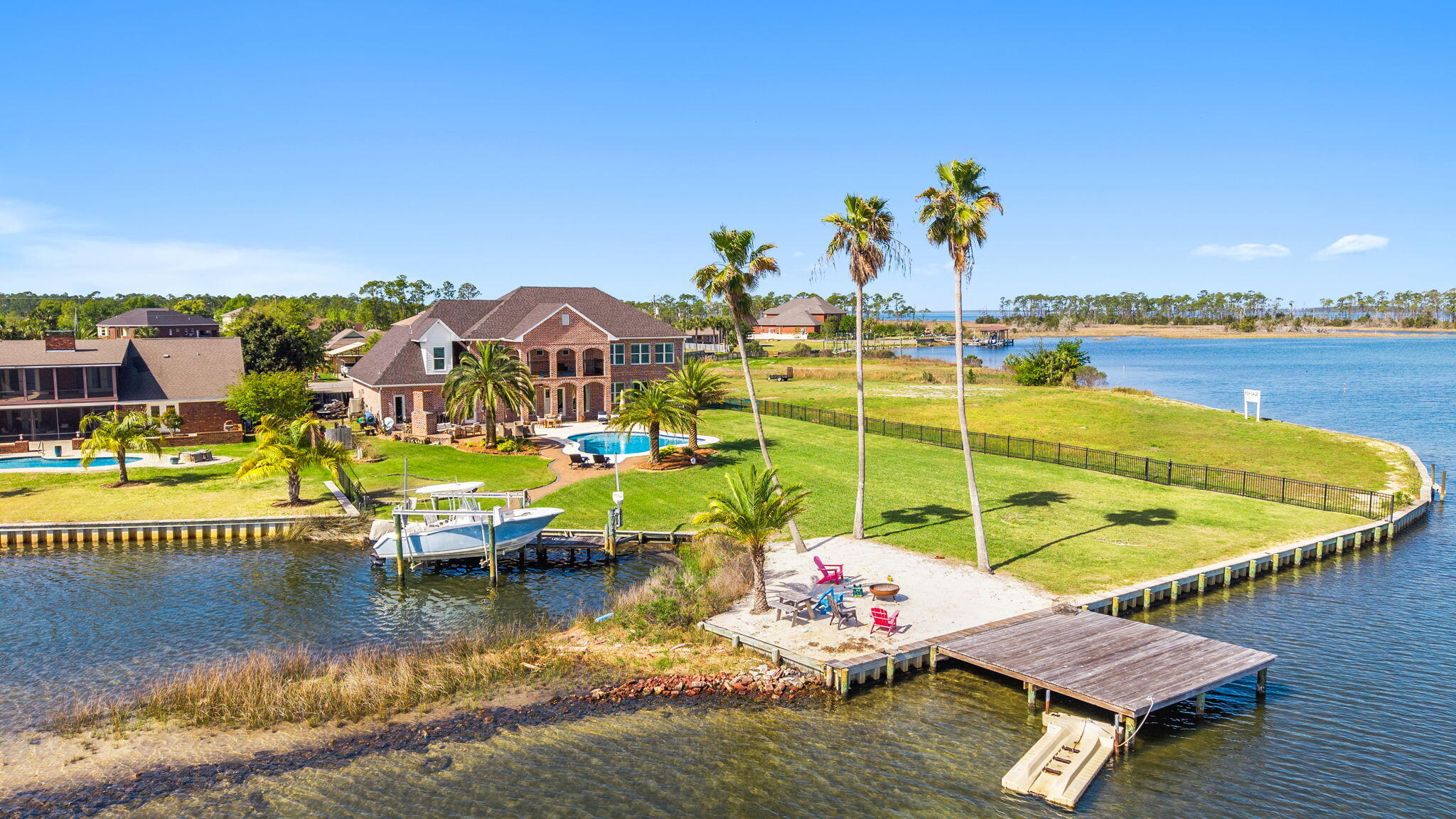 Coastal living at its finest AND featured on HGTV Amazing Water Homes! Discover your WATERFRONT slice of paradise in the heart of Lynn Haven, Florida, where everyday living feels like a permanent vacation. This stunning 2-story, 5-bedroom, 6-bathroom home with NO HOA features 5,575 square feet, a private pool TWO docks for your boats and with pure Bay views, it offers the perfect blend of Florida charm and modern comfort, just minutes from pristine beaches and world-class fishing out your back door.

Where privacy meets paradise, this bayfront estate is nestled on a quiet cul-de-sac with 130' water frontage on Upper Goose Bayou. This magnificent home sits on an expansive .79-acre homesite featuring your own private beach area and TWO private boat docks. Wake up each morning in the luxurious main-level primary suite to breathtaking water views from all angles. Move to the living room, open the French doors and enjoy the sea breezes from your covered back porch.

You're going to love the oversized bedrooms, walk-in closets and high ceilings in this home! This estate also features a large bonus/flex room centered in the middle of the bedrooms upstairs as well as a very large flex bonus room which is great for an additional game room, storage for holiday items or even an additional bedroom, if needed. The upstairs is complete with a kitchenette and laundry for easy access and entertaining, as well. A home office is on the main level and just across from the primary suite giving easy access to pop in to work when needed in early hours or late evenings without interrupting the family. The family room flows on the main floor flows seamlessly from the foyer and provides extra-large picture windows and French doors with views to the Bay. The formal dining room sets the stage for holiday gatherings and separation when needed while providing additional seating for daily use. The kitchen is a showpiece blending a transitional feel with beautiful light cabinetry, a walk-in pantry, an island overlooking the pool and Bay and an abundance of cabinetry. 

Picture living in your own personal resort with this oversized estate homesite and dive into your private pool after a day of boating or fishing, or cast a line right from your backyard dock. The gorgeous brickwork adds timeless elegance to this coastal retreat, where every detail speaks to quality craftsmanship with a fireplace and multiple seating areas to gather. If you're looking for a family home for generations to come, this one checks all the boxes. Room for your family to grow, room for your family to host and room to truly LIVE the coastal waterfront lifestyle you've dreamed about!

Just outside of Panama City, Lynn Haven's vibrant community offers small-town charm with big-city amenities, from waterfront dining to family festivals. With top-rated schools nearby and Panama City Beach's sugar-white sands just moments away, this isn't just a home, it's your gateway to the ultimate Florida lifestyle.

Homesites this large with NO HOA rarely come available. Don't miss this opportunity to own a slice of waterfront paradise in Florida!