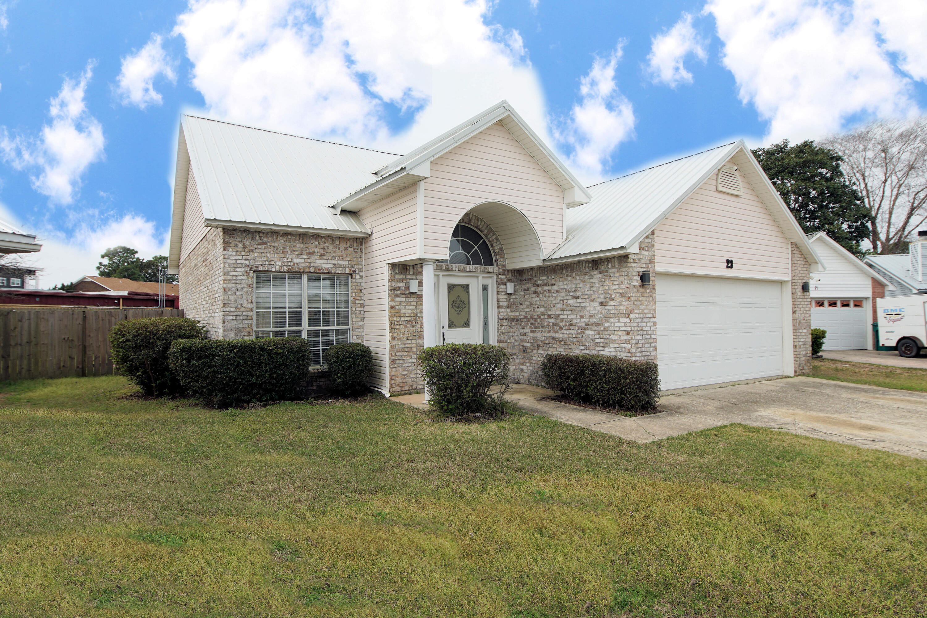 Beautiful home close to the white sandy beaches, military bases, and restaurants with 3 bedroom and 2.5 baths and 1963 sq ft! This home was built in 1994 year and features a metal roof (2021)! The interior of the home newly painted (2024). The exterior of the home has a two car garage and parking for extra vehicles outside of the garage. The front door has sidelights with a large transom. There is a fenced back yard and an open patio. Enter the home and the foyer opens to cathedral ceilings in the living room. The living room has a fire place, ceiling fan, and recessed lighting. There is a separate dining room adjacent to the living room and the kitchen. The kitchen has a large island that seats 4-5, a side by side refrigerator with icemaker, built in microwave, and slide in stove! There is also an eat in area in the kitchen. There is travertine tile flooring laid on the diagonal throughout the kitchen, dining room, and half bathroom. There is also a travertine backsplash. The primary bedroom has a large walk in closet with shelving. The ensuite primary bathroom has a large vanity, soaking tub, and walk in shower. The master has a private exit onto the outdoor, open patio through the sliding glass doors. Upstairs there are two additional guest bedrooms and a large guest bathroom with a tub and shower combination. The laundry room has travertine tile flooring, a wash basin, shelving, and is very large! This home is minutes to the beaches and military bases! Buyer to verify all dimensions and information. Refrigerator in the photo has been replaced.
