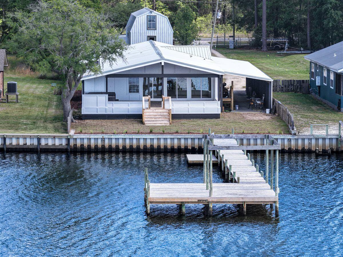 Must-see, beautifully remodeled waterfront home with charming cottage-style appeal and stunning East Bay views. Features include Calacatta Carrara quartz countertops, soft-close cabinetry, solid wood doors, gas appliances, and new tongue-and-groove pine flooring throughout. Enjoy outdoor living on the expansive covered patio overlooking the water, plus a brand-new boat dock and swim platform--perfect for the waterfront lifestyle. Offering over 2,300 sq ft, this permanently installed modular home meets local building codes with full insurability and financing options. Split floor plan with 4 bedrooms. Ideal as a primary residence, long-term or short-term rental property.