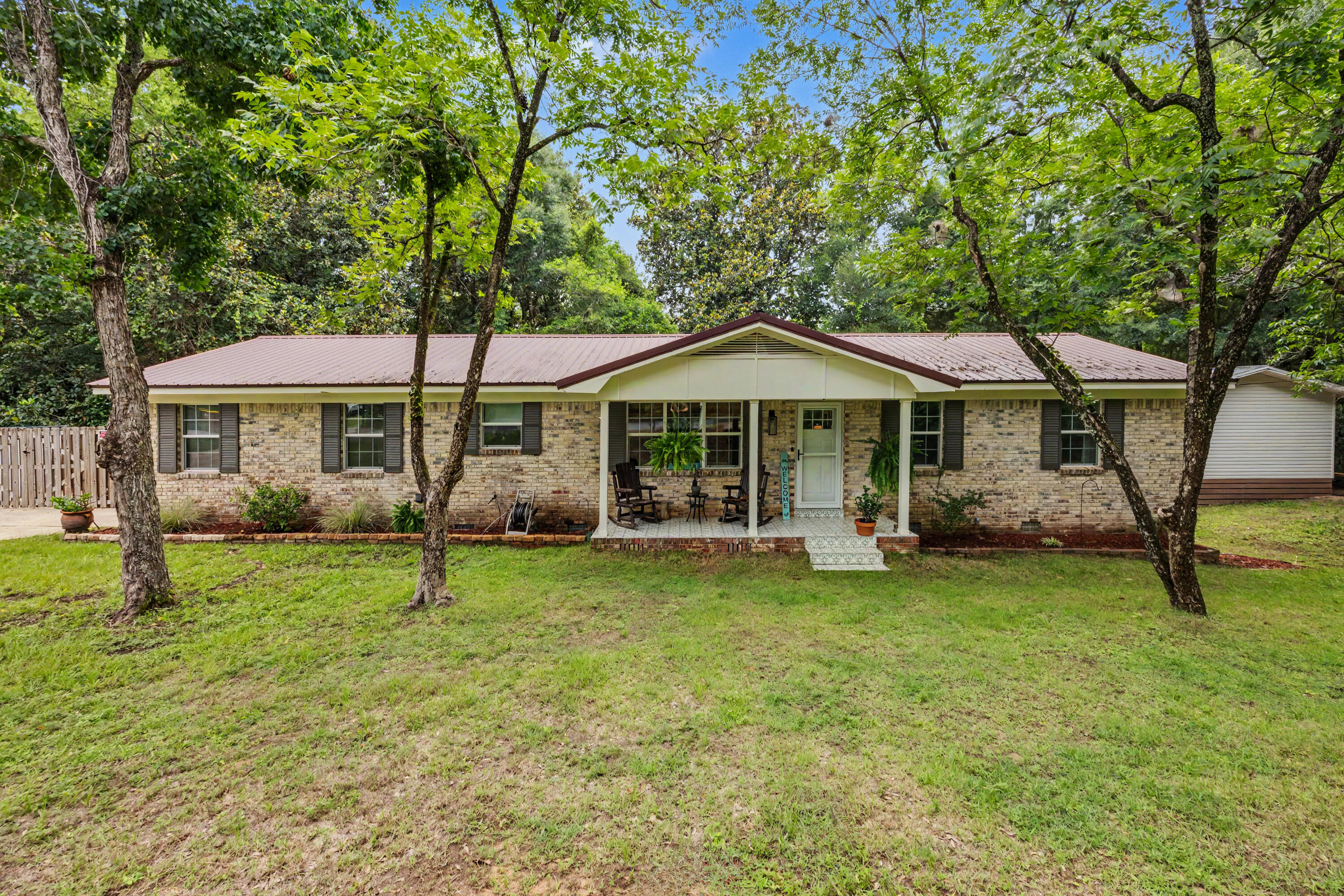 Welcome home! Nestled on a private, tree-shaded .34-acre lot just minutes from downtown Crestview, this beautifully updated farmhouse-inspired home offers the perfect blend of character, space, and flexibility. The main home features an open-concept living, dining, and kitchen area with luxury vinyl flooring, raised ceilings, a spacious island, quartz-style countertops, modern cabinetry, stainless appliances, and abundant natural light. The split layout includes 3 bedrooms and 2 updated bathrooms, providing room for everyone plus a separate living area with barn-style door adds versatility for a media room, playroom, or home office. Step outside to enjoy the covered front porch, fenced backyard, patio entertaining space, mature trees, and peaceful surroundings. One of the property's standout features is the detached accessory dwelling unit (ADU), offering endless possibilities for guests, multi-generational living, a home business, hobby space, or potential rental income. Over 600 soft, this ADU has it's own bedroom, bathroom, laundry and efficiency kitchen! Additional features include a metal roof, updated finishes throughout, privacy fencing, and a convenient location near shopping, dining, schools, and major commuter routes. A rare opportunity to own a property with both charm and income-producing potential in the heart of Crestview!