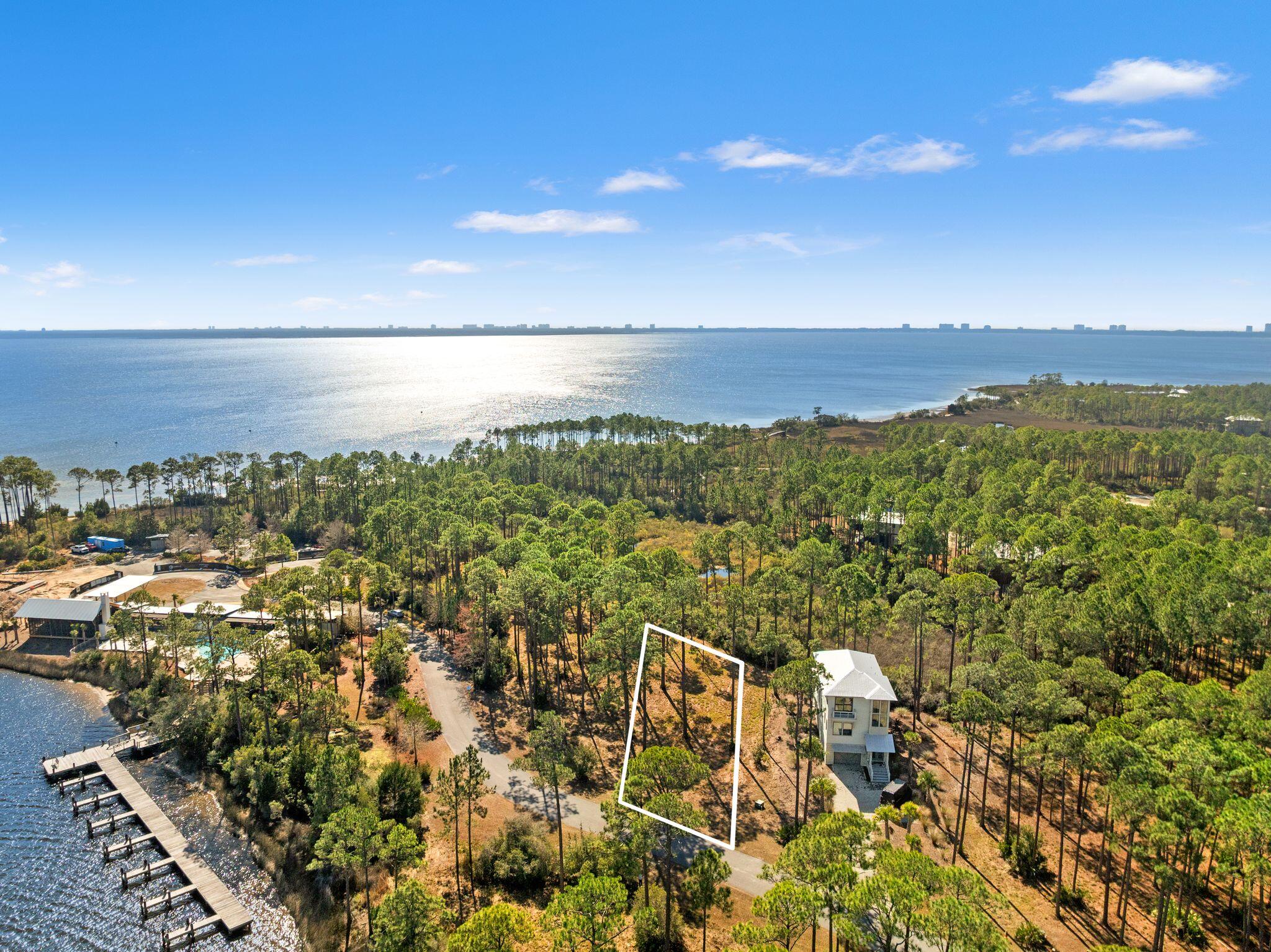 Capture breathtaking unobstructed views of Crooked Creek from this rare premium homesite in RiverCamps. Lot 127 is ideally positioned to take full advantage of the surrounding waterfront scenery, offering an exceptional opportunity to build a custom home in one of Panama City Beach's most sought-after gated communities. This homesite features paved road access to the property line — no gravel roads — and is located just steps from some of the community's best amenities, including the resort-style pool, day-use boat slips, community pier, playground, and a new fitness center currently underway. RiverCamps spans 1,500 acres with over 1,000 acres dedicated to conservation and fewer than 450 total homesites, creating a private, nature-rich setting. Residents enjoy direct access to Crooked Creek, West Bay, and the Intracoastal Waterway with a private boat ramp, dry boat storage, and on-site boat launch access. Additional amenities include seven miles of trails and boardwalks, pickleball and basketball courts, and a creekside campground with bathhouse. Situated just 10 minutes from Northwest Florida Beaches International Airport, approximately 10 miles from Pier Park and the Gulf's white-sand beaches, five miles from the new medical plaza, and two miles from a recently announced Publix-anchored retail development. Build your dream home and enjoy waterfront living, boating, and nature at its finest.