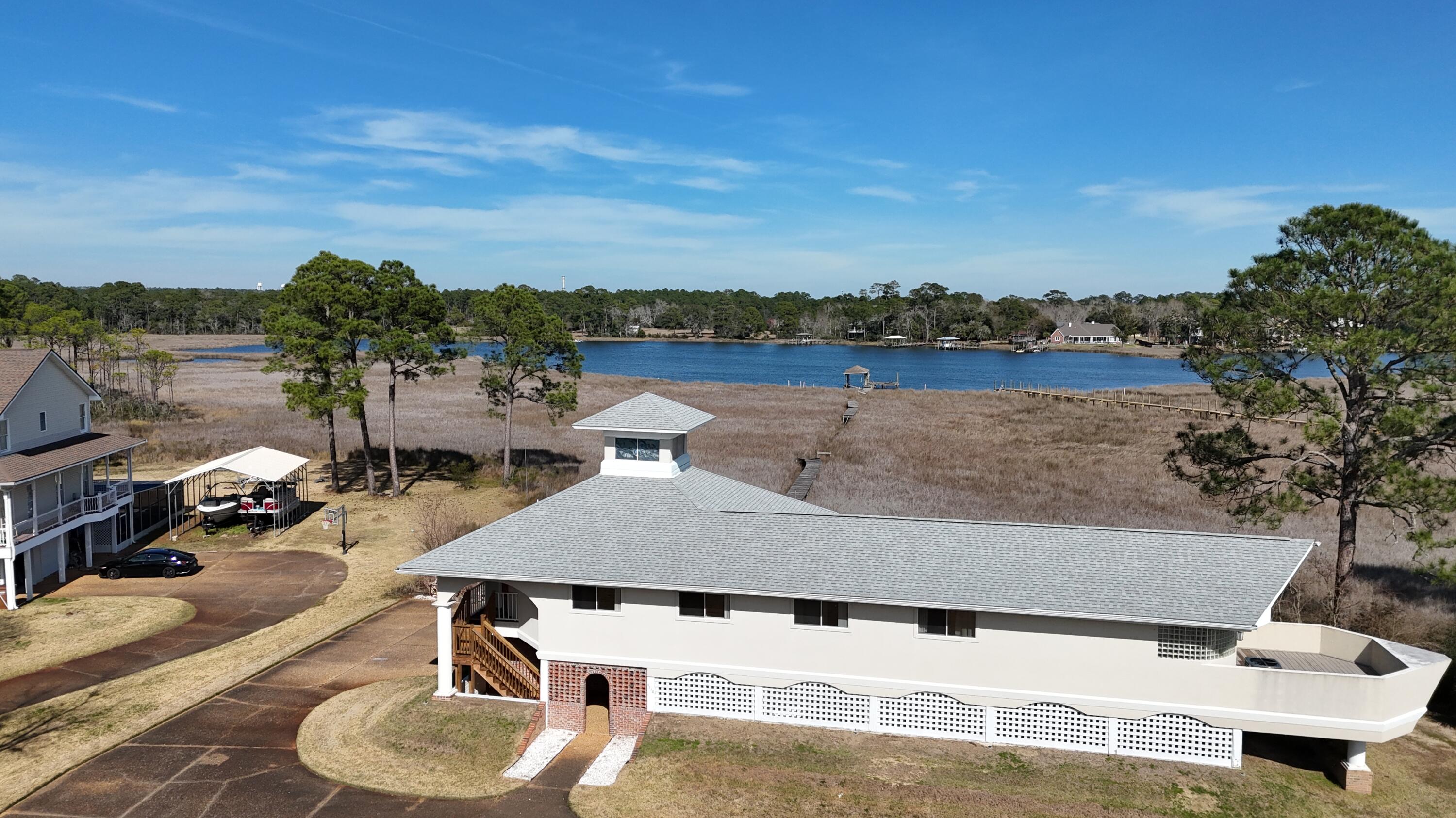Some homes sit near the water. This one lives on it.
Imagine stepping outside each morning and walking down to your private dock as the sun rises over the bay. The water is calm, the breeze is cool, and the only sounds are the birds overhead and the gentle movement of the bayou. It's the kind of peaceful waterfront lifestyle most people only experience on vacation.
Situated on nearly two acres along the bayou, this property offers something increasingly rare along the Gulf Coast: room to spread out, breathtaking water views, and direct access to the waterfront right from your own backyard. Whether your perfect day involves boating, fishing, kayaking, entertaining friends, or simply enjoying the view from the porch, this property was designed around the water and the lifestyle that comes with it.
As you arrive, you'll immediately notice the sense of privacy and freedom that surrounds the property. With expansive outdoor space and no concerns about where to keep your boat, RV, or recreational equipment, you'll appreciate the flexibility that's becoming harder and harder to find.
Step inside and you'll discover a home that embraces its surroundings. Large windows bring natural light into the living spaces while framing beautiful views of the water beyond. The main living area creates an inviting atmosphere for gathering with family and friends, where conversations flow easily and every room feels connected to the outdoors. The kitchen serves as the heart of the home, offering plenty of space to prepare meals, entertain guests, and create memories around the table. Nearby, the formal dining area is ready for holiday celebrations, family dinners, and special occasions, while additional living spaces provide flexibility for the way you live.
For those working remotely or simply needing dedicated space, the office offers a quiet retreat to focus and be productive. An exercise room creates the convenience of staying active without leaving home, while the workshop provides endless possibilities for hobbies, projects, storage, or creating the ultimate workspace.
At the end of the day, the primary suite becomes your personal retreat. Complete with its own sitting area, it's the perfect place to unwind, enjoy a good book, or simply relax while taking in the peaceful atmosphere that surrounds the property.
Outside is where this home truly becomes something special.
The private dock creates a direct connection to the water and the lifestyle that comes with it. Spend your afternoons fishing from your backyard, launching a kayak, exploring the bay, or simply enjoying the ever-changing scenery. Wide bay views stretch across the horizon, creating a stunning backdrop for everyday life and unforgettable gatherings.
The expansive property offers room for outdoor entertaining, gardening, pets, recreation, and future possibilities. Whether you're hosting summer cookouts, gathering with friends around the water, or enjoying a quiet evening watching the sunset reflect across the bay, every corner of this property encourages you to slow down and enjoy the moment.
Located in the Avalon Beach area of Milton, you'll enjoy the best of both worlds--peaceful waterfront living with convenient access to shopping, dining, schools, healthcare, and major routes connecting you to Pensacola, Pace, and the surrounding Gulf Coast communities.
Properties offering nearly two acres, private waterfront access, a private dock, wide bay views, and the freedom to truly enjoy your property are becoming increasingly difficult to find.
This isn't just a home on the water.
It's a place where every day feels a little more like the life you've been working toward.