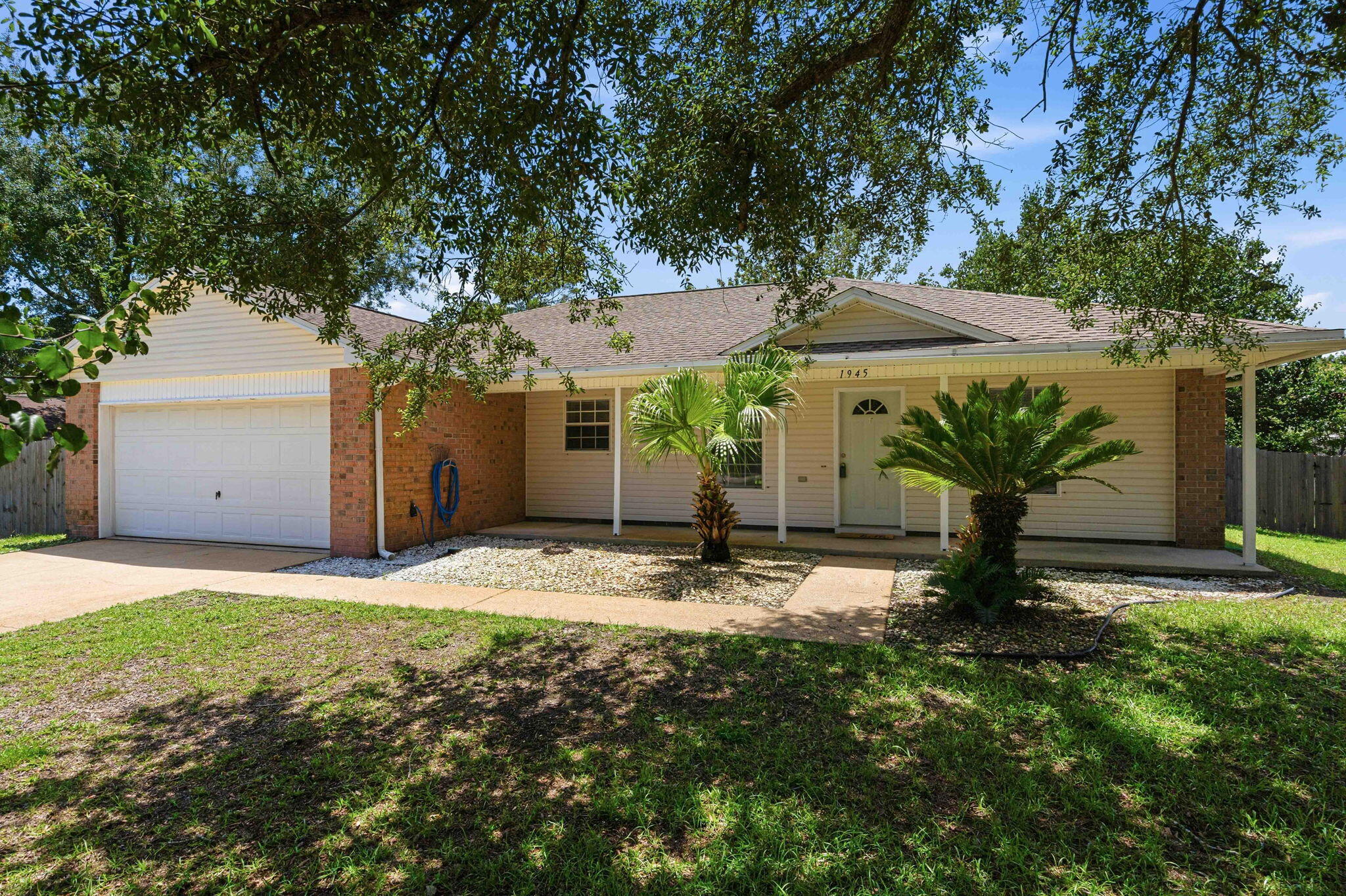 Welcome home to this beautiful 3 bedroom, 2 bath residence in the highly sought-after Holley By The Sea community. Nestled beneath mature oak trees on a spacious lot, this property offers the charm, privacy, and outdoor space that make Holley By The Sea so desirable.

Inside, you'll find fresh interior paint and a functional split floor plan designed for comfortable everyday living. The spacious living room features a cozy fireplace as its focal point, creating a warm and inviting atmosphere for gathering with family and friends. The kitchen flows seamlessly into the main living areas, while the split-bedroom layout provides privacy for the primary suite.

The covered back patio overlooking the fully fenced backyard is perfect for relaxing in the shade. The welcoming front porch offers the ideal spot to enjoy your morning coffee while taking in the beauty of the mature trees and established landscaping.

With its generous lot size, thoughtful floor plan and large lot, this home combines comfort, character, and functionality in one of Navarre's most popular neighborhoods. Enjoy all the amenities Holley By The Sea has to offer while being just minutes from schools, shopping, dining, and the white-sand beaches of the Gulf Coast.