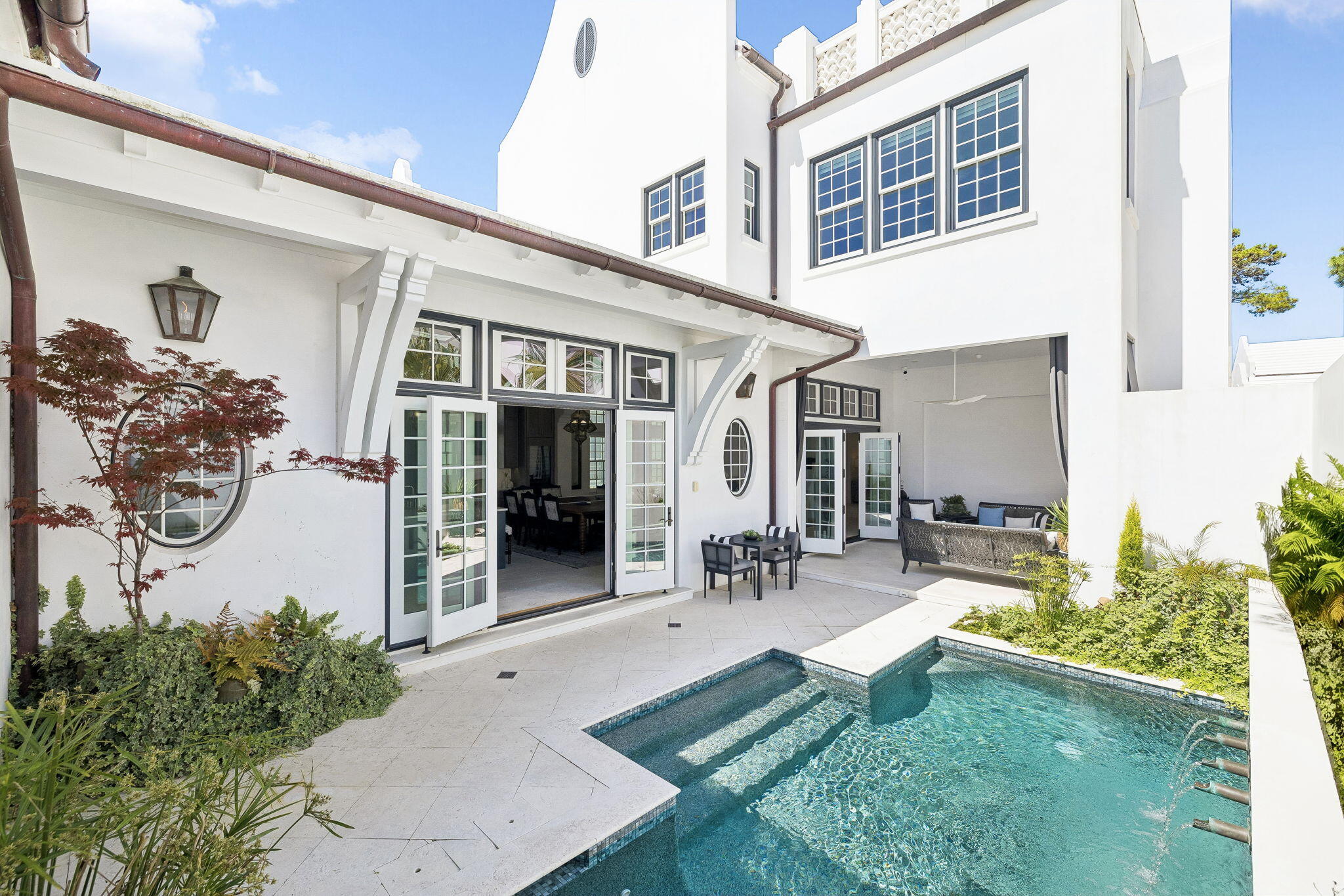 Thoughtfully positioned along the meandering path of Turtle Bale Park North, this exceptional four-bedroom, seven-bathroom residence offers nearly 3,900 square feet of beautifully designed living space and captures the essence of refined coastal living in Alys Beach. From the moment you enter the stately foyer, the home opens into expansive, light-filled interiors where open-concept living seamlessly blends comfort, elegance, and effortless entertaining.
The chef's kitchen is both stunning and functional, appointed with premium Miele appliances, abundant custom cabinetry, and a thoughtfully designed scullery that provides additional prep space, storage, and organization. Throughout the home, an abundance of storage ensures practicality without compromising design.
A junior primary suite on the main level offers privacy and flexibility for guests or multi-generational living. Upstairs, additional guest suites provide luxurious accommodations, while a spacious upper terrace delivers sweeping panoramic views and one of the most breathtaking sunset vantage points in Alys Beach.
Designed to blur the line between indoor and outdoor living, the private courtyard features a sparkling pool, outdoor seating, grilling area, and a cozy fireplace. Expansive nano doors fully open the living space to the courtyard, creating an incredible setting for entertaining and relaxation. Enhancing the experience further are surround sound, full home automation, and a distinctive Moroccan-inspired aesthetic that adds warmth and character throughout.
Additional highlights include an architectural staircase that anchors the home's grand design, an oversized two-car garage, and elegant finishes throughout. Offered partially furnished, this extraordinary residence embodies luxury coastal living at its finest and truly checks every box for the discerning Alys Beach buyer.
Alys Beach offers a lively town center with curated dining and shopping options that create a true resort-style atmosphere.  The community is designed by thoughtful green spaces as well as the renowned Alys Beach Homeowner Amenities.