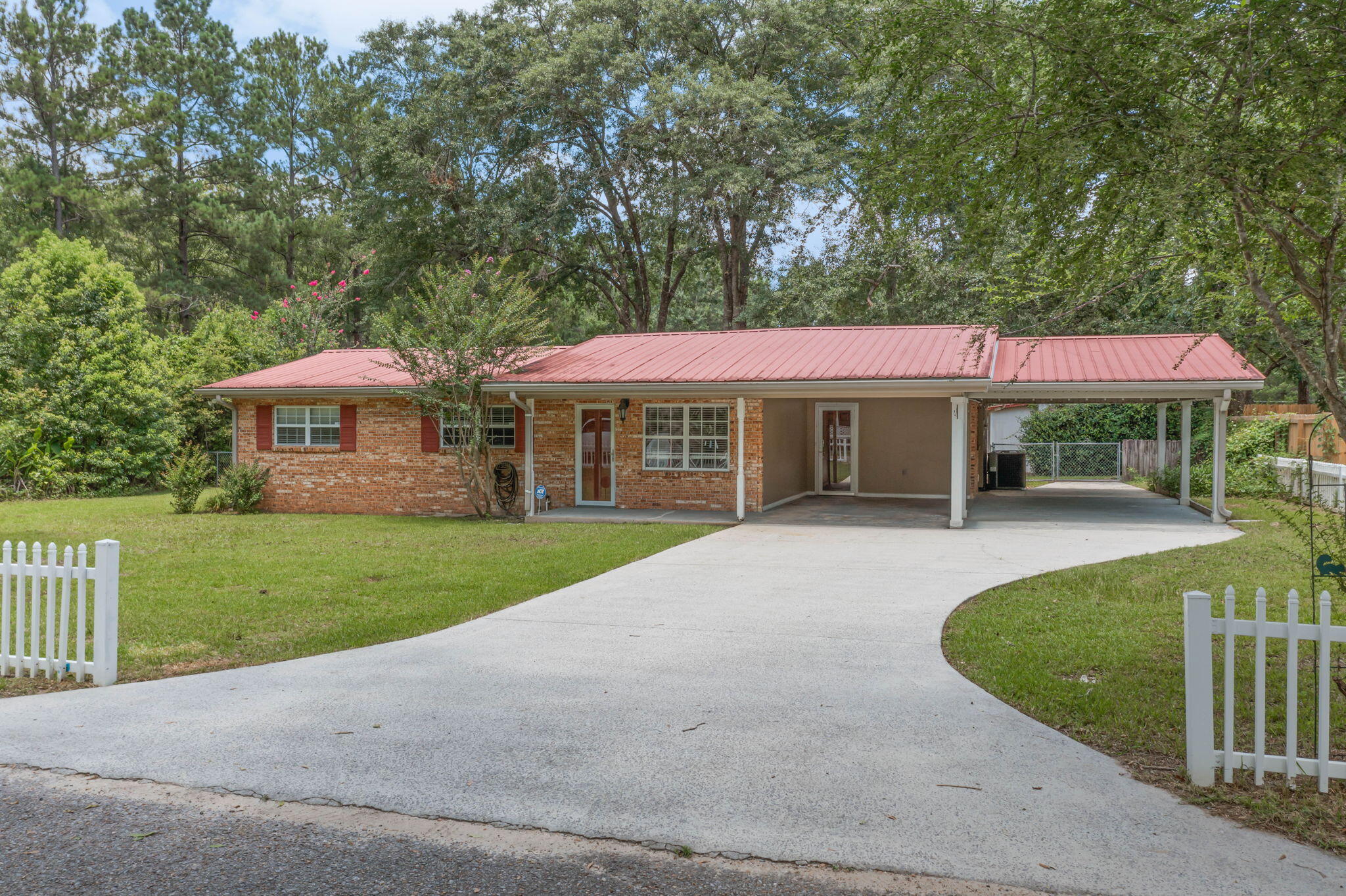 Beautifully updated brick home tucked away at the end of a quiet street in the heart of Bonifay. Recent improvements include quartz countertops, fresh interior paint, updated light fixtures, and all new flooring throughout the home. The kitchen features stainless steel appliances, a breakfast bar, and ample cabinet space. The versatile floor plan offers multiple living areas, including a spacious sunroom, two bonus rooms, and a unique primary suite featuring two walk-in closets and an additional connected space that could serve as a nursery, home office, sitting room, dressing room, fitness area, or private retreat. Outside, you'll find a metal roof, covered front porch, open patio, two-car carport, fenced backyard, and two large powered outbuildings. One offers endless possibilities as a hobby space, craft room, she shed, man cave, workshop, or additional storage and includes an attached covered lean-to. The second, larger building features a spacious workshop/storage area with shelving already in place, along with a generous covered area for equipment, projects, or additional storage. Conveniently located near shopping, dining, schools, and everyday amenities, this property offers modern updates, versatile living space, and exceptional storage both inside and out. Additional Features:

* Oversized bonus/flex room with closet
* Double-pane vinyl windows
* Updated electrical service with breaker panel
* Full-size washer and dryer included
* Laundry room with built-in cabinetry
* Gas range