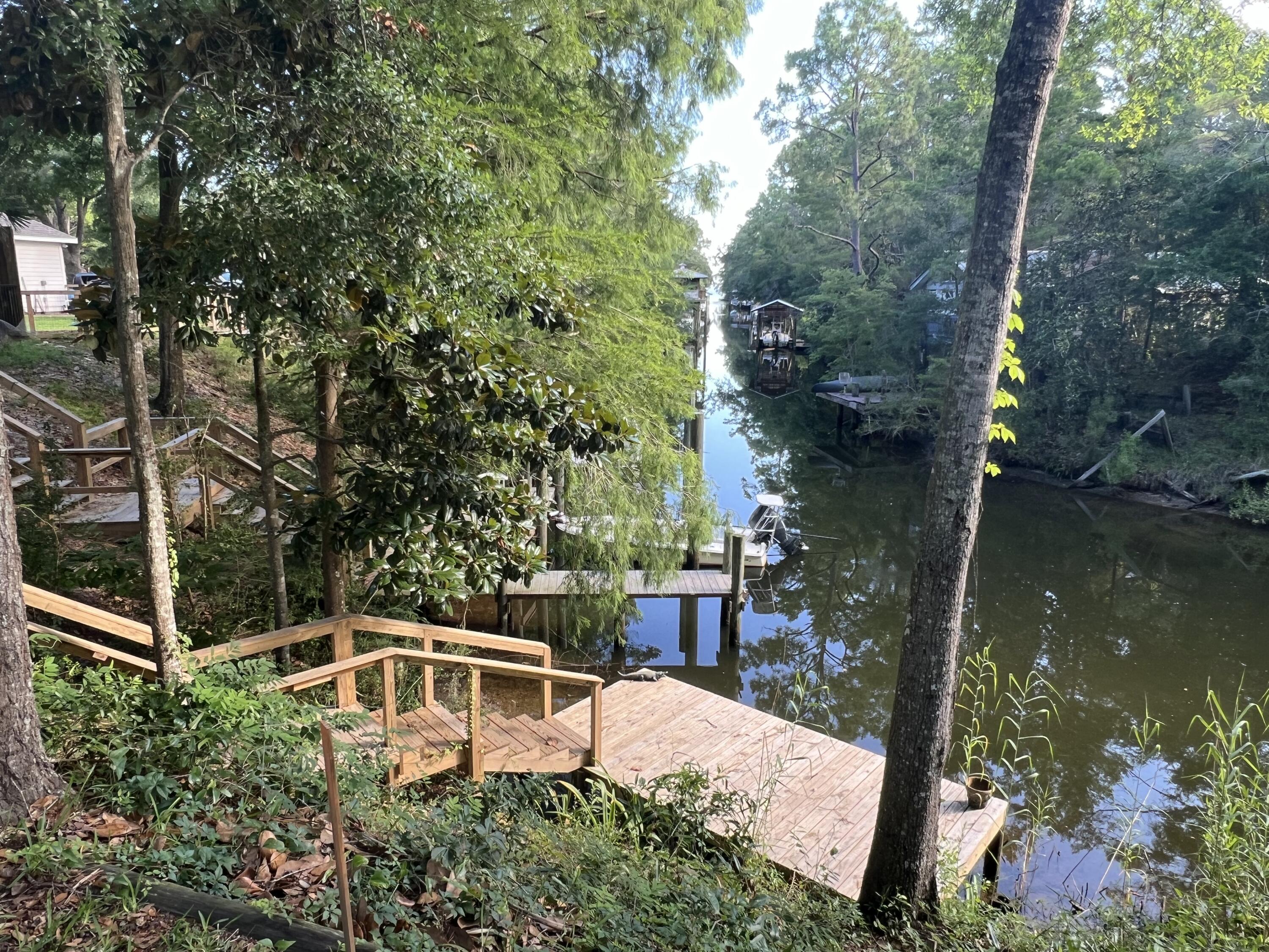 Rare opportunity to build in a charming coastal community in Santa Rosa beach. This beautiful homesite is shaded by stunning mature live oaks and located in a quiet neighborhood with NO HOA. The lot overlooks a canal connected to the bay, offering breathtaking sunset views and easy water access. The brand new dock has been recently built, perfect for boating, kayaking or paddle boarding and exploring Choctawhatchee Bay. Enjoy peaceful coastal living just minutes from the white sandy beaches along the Gulf of Mexico. Nearby shops and restaurants. Ideal for building a primary residence, vacation home, or investment property.
