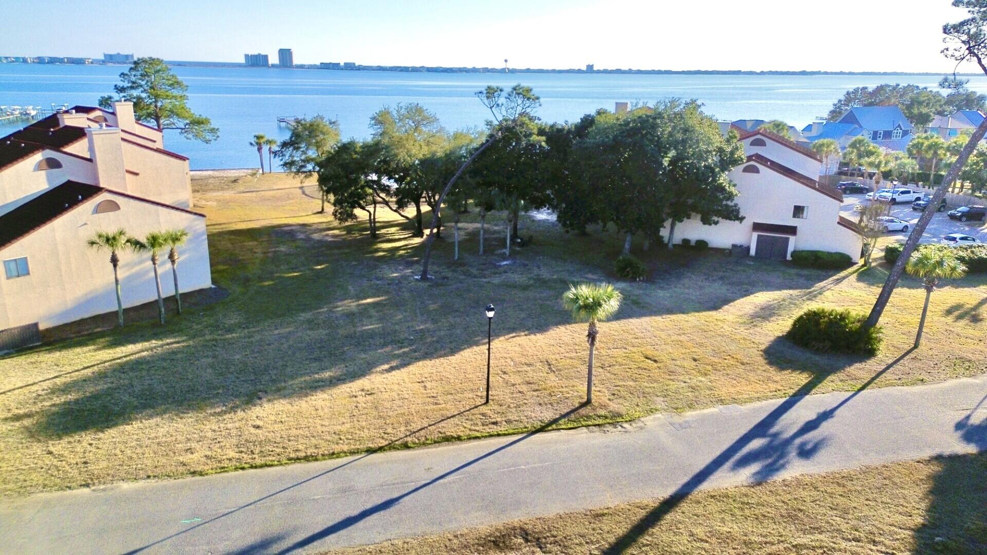 Exceptional Navarre Beach development opportunity. Offered is one of two available parcels (each priced the same), zoned R2 with flexible residential use including single-family, townhomes, and carriage homes. Parcel is currently .30 acres and planned to be split into two .15-acre homesites. Both lots will enjoy beautiful views of the Navarre Beach Sound and include easement access to the waterfront via a dedicated walking path. Located within a gated community with no HOA or restrictive association fees. Prior concepts included three townhomes with a pool or pickleball court if both parcels are acquired. Less than 5 minutes to Navarre Beach. Buyer to verify all information.