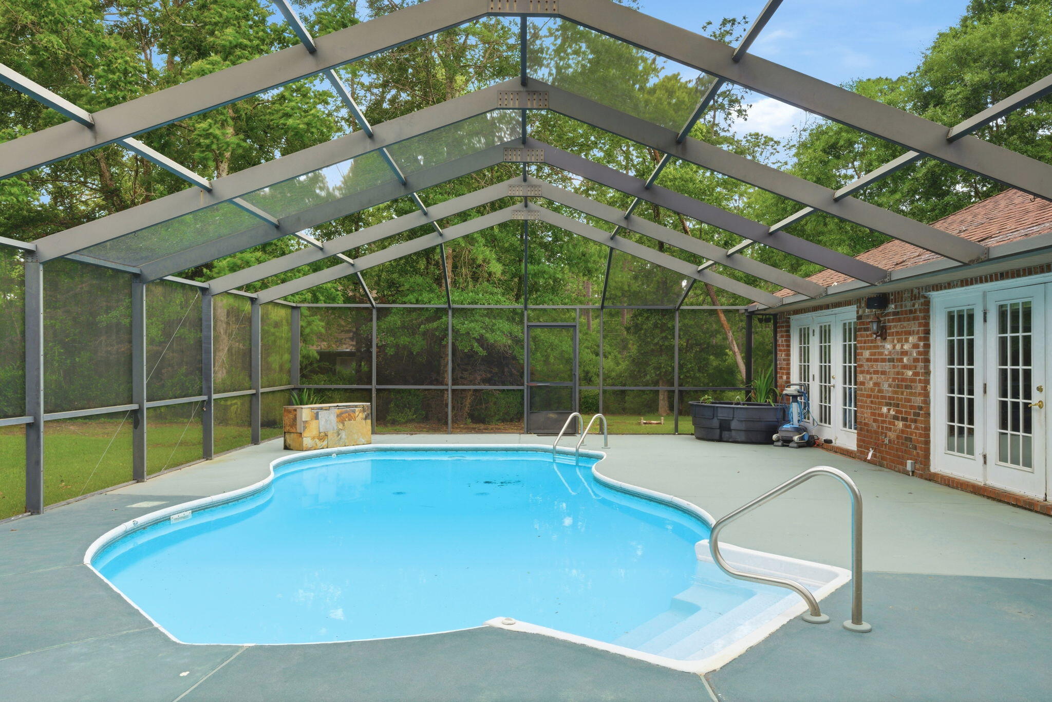 Welcome to this gorgeous private estate featuring a sparkling pool with waterfall feature, nestled on just under 9.8 acres in beautiful Northwest Florida. This stunning four-bedroom, three-full-bath home offers the perfect blend of comfort, privacy, and outdoor recreation. Inside you'll find a spacious kitchen designed to impress with white cabinetry accented by glass-style doors, sleek quartz countertops, a gas stove, and stainless steel refrigerator. The thoughtfully designed layout allows multiple rooms along the back of the home to showcase beautiful pool views while also providing direct outdoor access, creating a seamless indoor-outdoor living experience. The front portion of the home offers additional versatility with a formal dining room and a flex space that can easily serve as a home office, second living area, playroom, workout room or additional entertaining space to fit your lifestyle needs. Step outside and experience everything this 9.72-acre property has to offer. A peaceful pond welcomes you near the front of the property, while cleared trails wind throughout the acreage ideal for side-by-sides, ATVs, golf carts, or other outdoor recreational vehicles. Adjacent to the pool area you'll discover a charming cottage-style cabin that adds even more character and functionality to the property. This unique space could serve as quest quarters, additional living space, a private retreat, playhouse, hobby room, or anything else that you can imagine. Surrounded by nature, this property delivers the privacy and serenity many buyers are searching for, complete with a private drive leading from the street up to the home. Whether you're looking for a personal retreat, entertaining space, or acreage to enjoy the outdoors, this one-of-a-kind property offers endless possibilities.