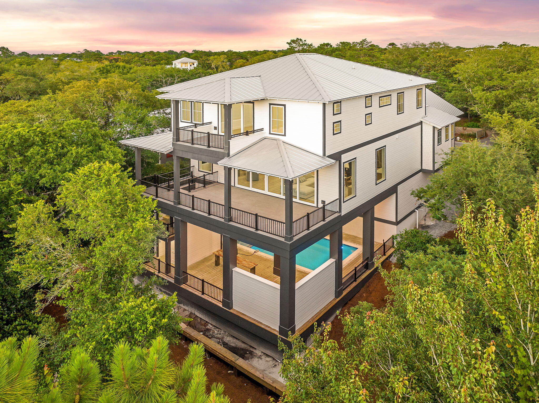 Set west of 30A in one of Dune Allen's most understated enclaves, 91 N Bishop Street brings new-construction precision within minutes of the Gulf. Stalworth Lake is just beyond the property, and the Beach Highlands access point remains one of the rare, uncrowded stretches of sand left on 30A.

The architecture is clean and modern coastal, impact-rated windows, clear lines, and a restrained palette that feels intentional rather than ornamental. Inside, the finishes land exactly where they should: wide-plank floors, custom cabinetry, designer lighting, and a main living level that moves seamlessly from kitchen to dining to outdoor space. The layout is built for both personal use and rental performance. Multiple ensuite bedrooms, a dedicated bunk landing, and generous covered porches make the home feel livable at scale. A private pool and fenced backyard create a resort environment without sacrificing privacy.

From morning coffee runs to Stinky's to evening bike rides along the dune lakes, the lifestyle here is effortless. Restaurants, boutiques, golf, and protected natural coastline sit within minutes. With no HOA restrictions and some of the highest elevation on 30A, this pocket delivers what most beach markets can't: quiet, flexibility, and long-term investment strength.