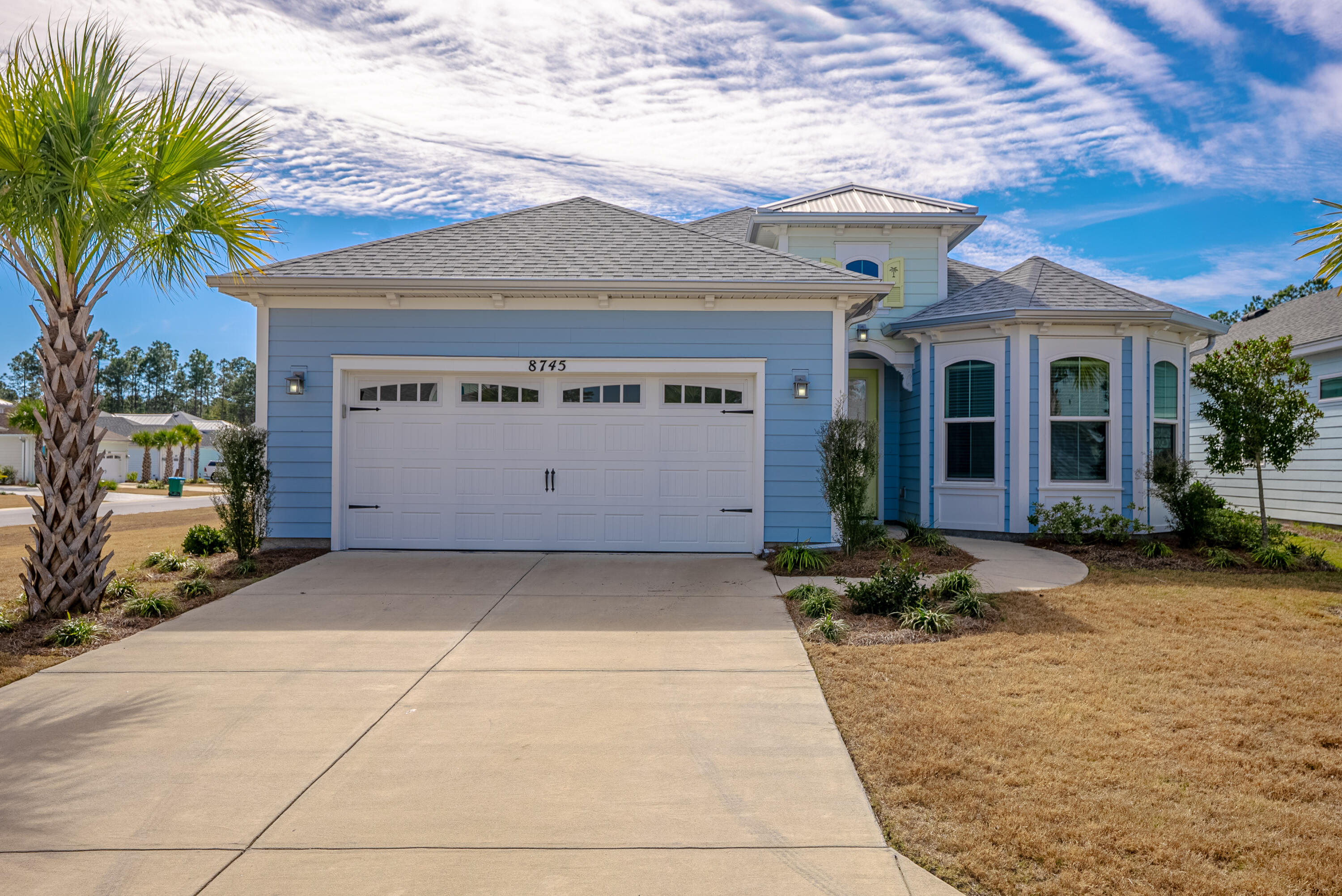 HUGE PRICE IMPROVEMENT! Experience easy resort-style living in Margaritaville with this beautifully maintained Breeze Bay corner-lot home. Featuring 3 bedrooms and 3 baths, it offers stylish vinyl plank flooring throughout. The chef's kitchen boasts quartz countertops, tile backsplash, wine cooler, gas cooktop, wall oven, microwave, and a large island, opening to the dining and great room. Sliders lead to a screened lanai with serene pond views. The primary suite includes his and her closets, dual quartz vanities and a gorgeous shower.  As a plus, there is  a private guest suite and a full bath just outside the 3rd bedroom.  Extras include appliances, custom blinds, epoxy garage and lanai, storage, and a whole-house generator. Enjoy 55+ amenities, lawn care, and nearby shopping and dining