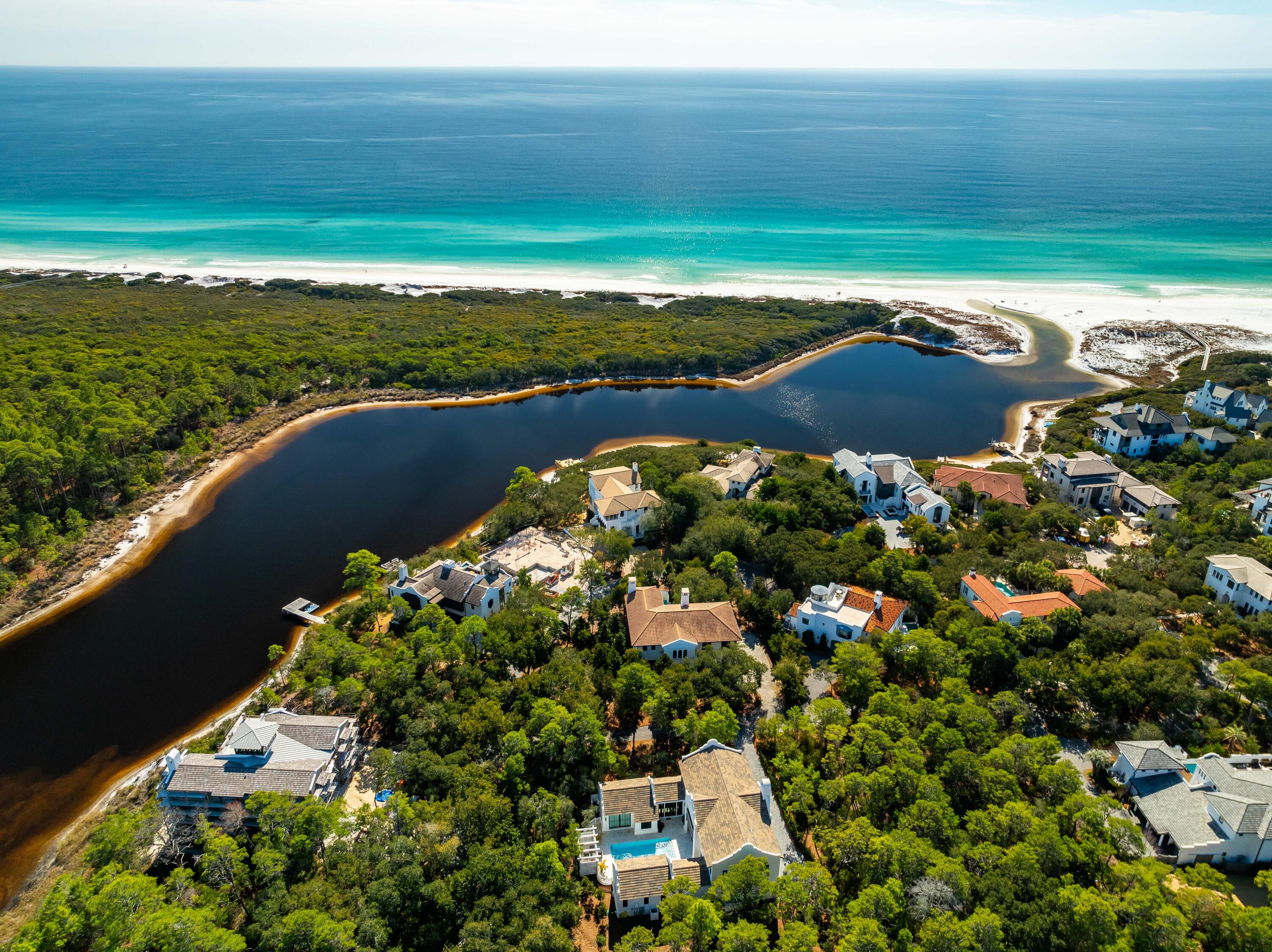 Tucked beneath a canopy of majestic Southern live oaks, this exceptional coastal residence is gracefully positioned on a large homesite with mature landscaping within an exclusive gated enclave near Little Redfish Lake. Just a short stroll from the Gulf with private deeded beach access, the property embodies the perfect balance of luxury, privacy, and relaxed coastal living.

Built in 2016, this thoughtfully designed 5-bedroom, 7-bathroom home spans 4,837 square feet and showcases refined craftsmanship paired with seamless indoor-outdoor living. A welcoming mahogany entry opens to sophisticated interiors and inviting entertaining spaces designed to embrace the surrounding natural beauty.

The heart of the home flows effortlessly into a stunning outdoor retreat featuring a heated pool, tranquil courtyard spaces, and multiple lounging areas framed by lush mature landscaping and towering live oaks. A spacious loggia with retractable screen, a summer kitchen, and one of three fireplaces creates the ultimate setting for year-round entertaining.

Each bedroom offers generous accommodations and private comfort, while additional luxury features include a private elevator, three fireplaces, and a spacious two-car garage. Located within a private, rental-restricted community, this remarkable residence offers an unparalleled opportunity to enjoy an elevated coastal lifestyle with exclusive beach access, exceptional privacy, and timeless coastal elegance.
