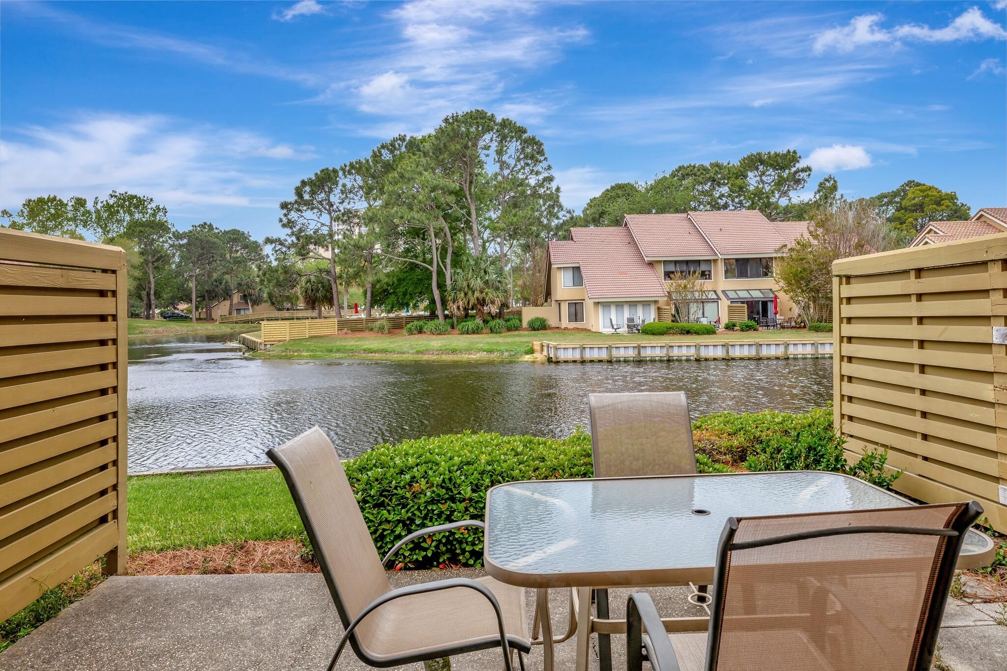 This beautiful lakefront 2BR/2.5BA villa is fully furnished & available for a 1-year lease is Available NOW. Tile floors extend throughout, ideal for sandy beach living & easy maintenance. The kitchen features granite countertops, ample cabinets, and stainless steel appliances. The common areas & a half bath are located on the first level, and both bedrooms, each with an ensuite bathroom, are located upstairs as well as the laundry room. The back patio is perfect for grilling & outdoor dining while enjoying the lovely views of the lake. The Beachwalk Villas community pool is just steps away & is seasonally heated for year-round enjoyment. You will love the ease & convenience of the proximity to the beach, Dunes Putting Course, the Beach House restaurant, and the Market Shops for