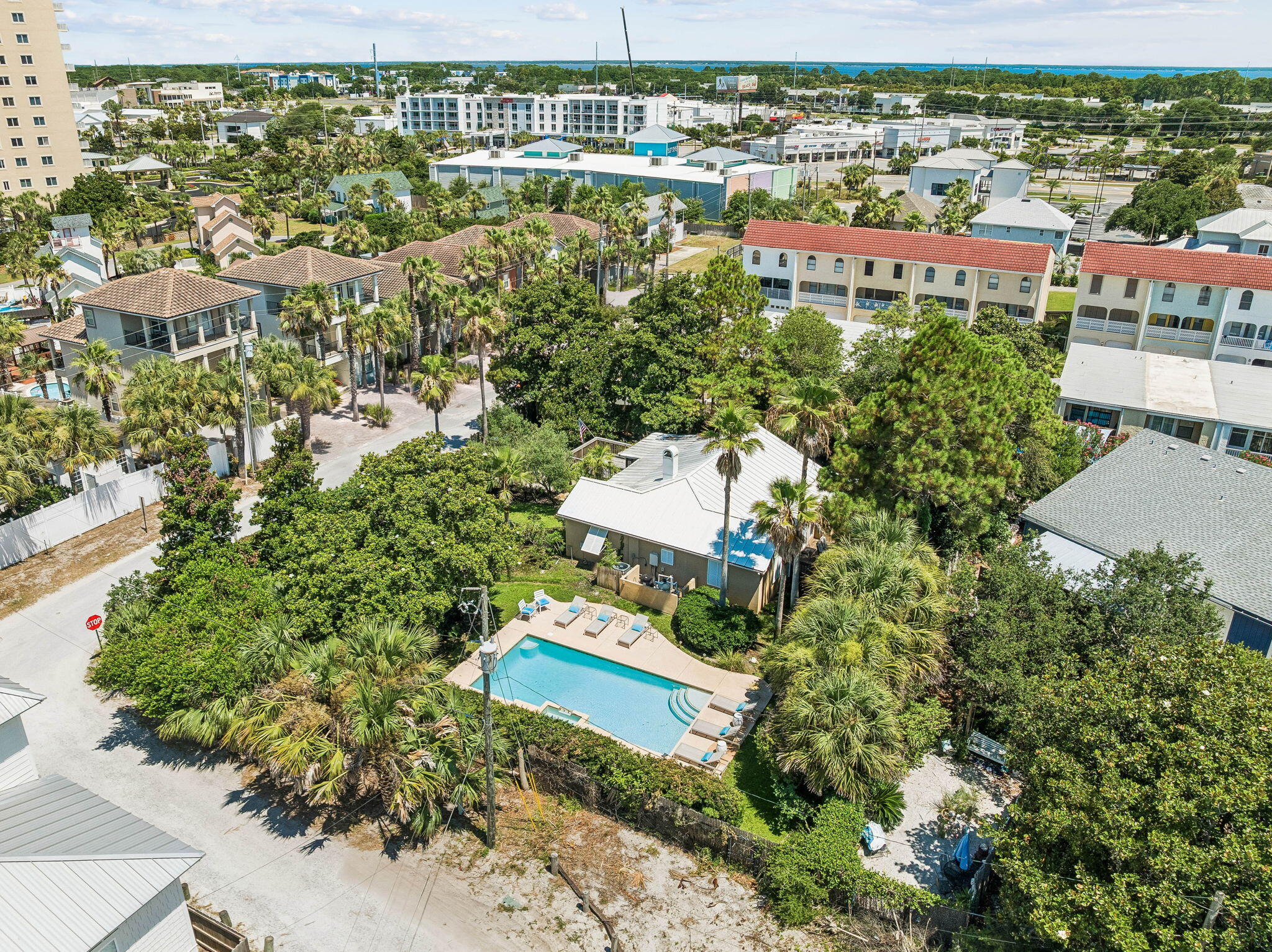 Rare opportunities like this are becoming increasingly difficult to find. This approximately 0.3 acre homesite sits just steps from the beach access across the  street and offers exceptional redevelopment potential, subject to buyer verification. Situated in the heart of Miramar Beach, this unique property combines an estate-sized homesite with an unbeatable location. Whether you're searching for a primary residence, second home, investment property, or exploring redevelopment opportunities, the possibilities are as compelling as the location itself. The beautifully landscaped grounds feature mature palms, shade trees, lush lawn, a private pool, and a fully fenced yard, creating a private setting rarely found this close to the beach. The home's elevated position enhances both privacy and outdoor enjoyment. The existing residence has been thoughtfully updated with granite countertops, upgraded cabinetry, and quality interior finishes. Built with durable concrete block construction, a stucco exterior, a metal roof, and hurricane shutters, the home also offers a spacious front porch with both screened and open-air living areas, plus a private rear porch overlooking the tranquil garden. Leave the car behind and enjoy one of the property's greatest advantages. Beach access is directly across the street, placing the sugar white sand and emerald green waters just moments away. Nearby destinations include Silver Sands Premium Outlets, Sandestin Golf and Beach Resort, Grand Boulevard, championship golf courses, restaurants, shopping, and entertainment.