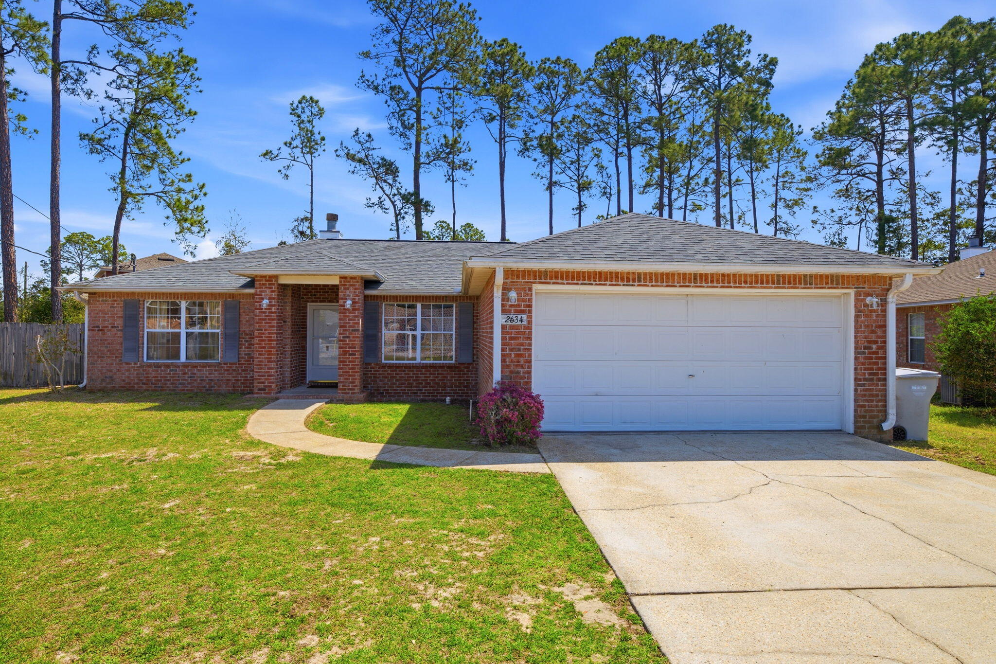 Welcome to this well maintained 3 bedroom, 2 bathroom, brick home in Navarre's Hidden Estates neighborhood. Located just minutes from the Hidden Creek Golf Course and the sugary white sands of Navarre Beach. Offering peace of mind with a 2022 Roof, 2024 HVAC system, 2024 Water Heater, fabric hurricane shutters, and a hurricane rated garage door. The interior features a split floor plan with fresh paint throughout, vaulted ceiling in the living room with a cozy fireplace, and plush new carpeting in the living space and bedrooms. The kitchen is equipped with solid oak cabinets, tiled flooring, a breakfast bar, and a dining nook with a beautiful bay window to let in natural lighting and to catch a view of the large, fully fenced-in backyard. The primary bedroom is just off the kitchen and has its own incredible ensuite bathroom with double vanity, walk-in shower, separate soaking tub, and double walk-in closets. The additional bedrooms and bathroom are on the opposite side of the home for added privacy. Schedule your showing today and make this your home on the Emerald Coast!