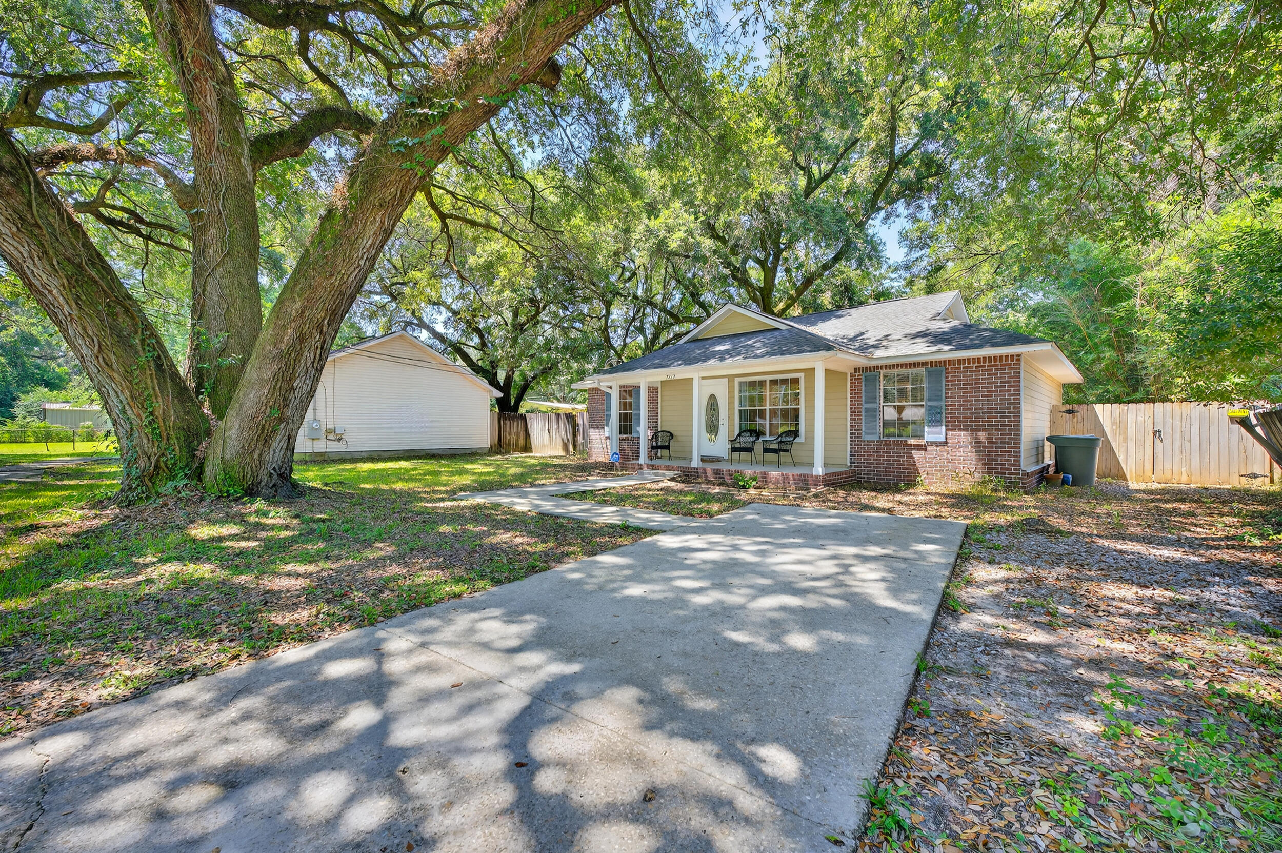 Welcome to this charming Pensacola home, conveniently located just off N Palafox! With NO HOA and plenty of driveway space, there's ample room for your boat, RV, or multiple vehicles. The property is set on a lot filled with mature live oaks, offering shade, beauty, and a peaceful setting. A covered front patio adds to the curb appeal and provides a charming spot to enjoy your morning coffee or unwind from the day. Step inside to find a comfortable layout designed for everyday living. The home features new carpet in 2 of 3 bedrooms and two spacious living areas, giving you flexibility for entertaining, relaxing, or creating a home office. The kitchen is complete with a pantry, plenty of cabinet space, and a breakfast bar for additional seating.  Just off the kitchen, the utility room pro vides even more convenience with an additional storage closet, direct access to the backyard, and a built-in doggy door for your pets! The primary suite is tucked away in its own hallway for added privacy and features an en suite bathroom with a tub/shower combo. On the opposite side of the home, you'll find two additional bedrooms. One is equipped with a walk-in closet. A full bathroom is situated between them, also with a tub/shower combo. Outside, enjoy a spacious backyard complete with a covered patio that's perfect for relaxing or entertaining, plus a storage shed for all your tools and outdoor gear. Move-in ready, this home offers a beautiful lot and great location in Pensacola!