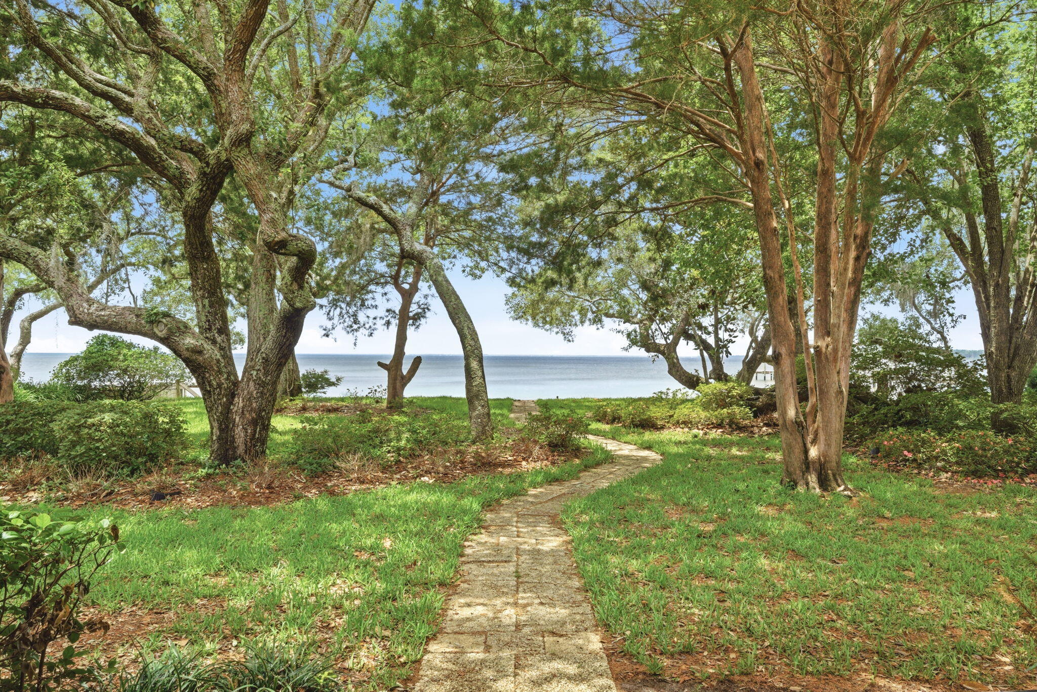 Welcome to peaceful waterfront living in the highly desirable Robledal Estates community...where winding oak-lined roads, quiet cul-de-sacs, and breathtaking sunsets create the perfect Emerald Coast lifestyle. This bayfront home is perfectly positioned to capture some of the most remarkable evening skies imaginable, with calming water views stretching right from your own backyard. 3 Bed / 2 full bathrooms 

Inside, the home features soaring 13-foot vaulted ceilings that make the living spaces feel open, bright, and inviting. The split floor plan offers privacy and functionality, with water views from the kitchen, living room, and two of the bedrooms. The third bedroom is thoughtfully positioned toward the front of the home, making it ideal for guests, an office, or additional family space.

Enjoy two full bathrooms, a deep oversized laundry room, and a spacious double-car garage with plenty of room for storage. The home still features some original interior finishes, giving the next owner a wonderful blank canvas to design and customize the waterfront retreat they've always envisioned. One of the biggest recent upgrades? The architectural shingle roof was replaced just a few months ago, a major benefit for both peace of mind and potentially achieving a more favorable insurance quote.

Step outside and truly embrace the waterfront lifestyle. Early mornings and peaceful evenings bring dolphins, kayakers, paddleboarders, fishermen, and coastal wildlife right past your backyard. Relax under the shade of mature oak trees while enjoying the bay breeze and unforgettable sunsets that make this location so special.

Tucked away among other beautiful waterfront homes, this peaceful setting still keeps you conveniently located only approximately 16 minutes from the white sandy beaches of Navarre Beach.

Best of all, there is no HOA whatsoever. Bring your vision, your boat, and your creativity to make this property your own waterfront masterpiece.

Need ideas for a dock or seawall? Please inquire -- we're happy to help connect buyers with local resources and quotes to make your waterfront dreams a reality.