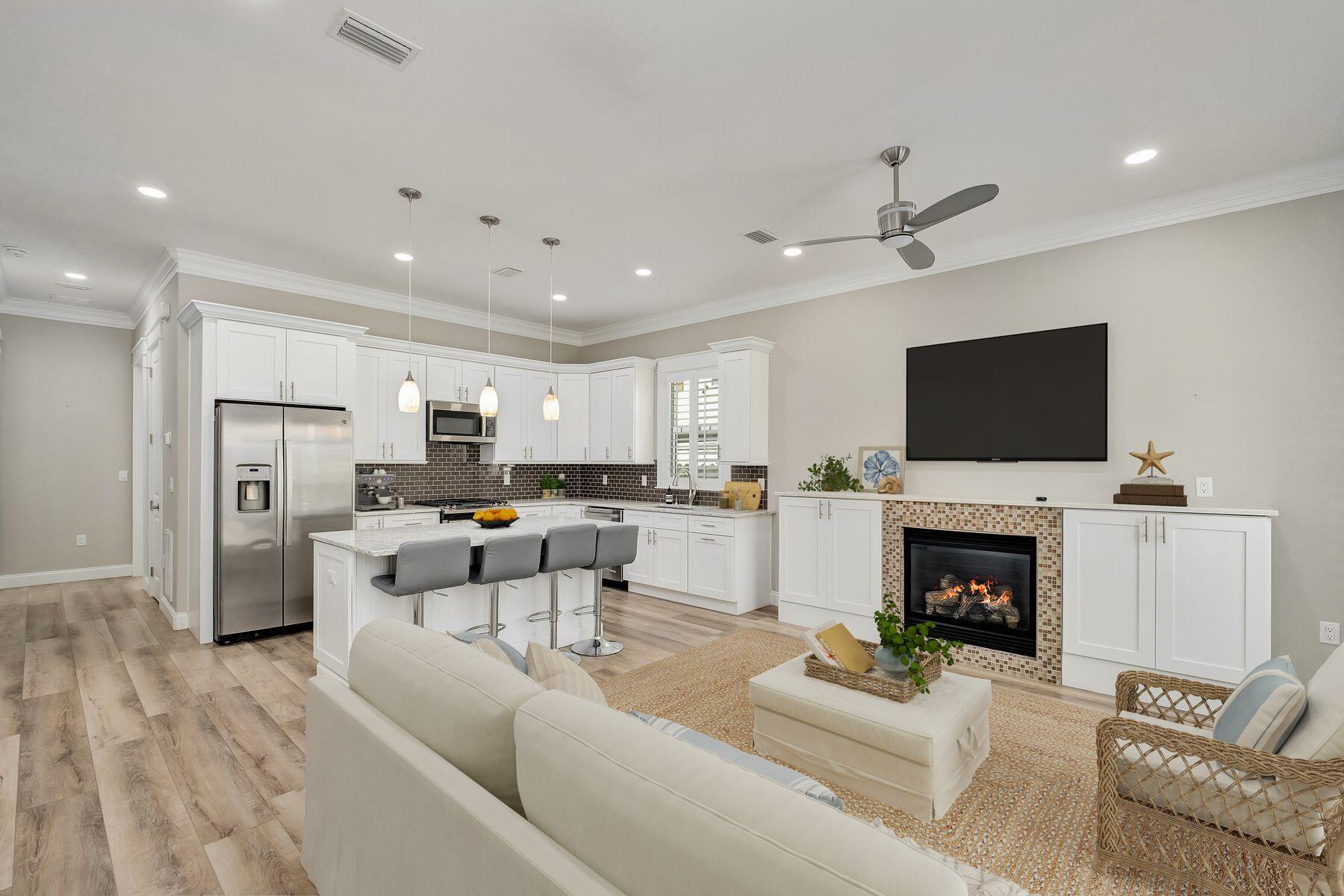 A rare opportunity to own a thoughtfully designed, recently built residence that prioritizes both comfort and ease, this single-story home offers a level of refinement seldom found at this price point. Completed in 2023, the property reflects intentional design choices and elevated finishes throughout. Inside, ten-foot ceilings and plantation shutters set a polished tone, while the open-concept layout creates a natural flow between living, dining, and kitchen spaces. A built-in gas fireplace framed by custom cabinetry anchors the main living area, adding warmth and architectural interest. The kitchen is equally impressive, featuring quartz countertops, a gas range, stainless steel appliances, and a generous workspace designed for both everyday living and entertaining. Both bedrooms are privately positioned at the rear of the home, each with its own ensuite bath, privacy windows, and direct access to the outdoor living area through sliding glass doors. The bathrooms are beautifully finished with custom tilework and frameless glass showers, and include a tub-and-shower combination in the secondary suite. A well-appointed laundry room includes additional cabinetry, a utility sink, and a washer and dryer that remain with the home. Outdoor living is equally considered, with a spacious paver patio designed for relaxing afternoons and casual gatherings. A retractable awning extends across the patio, offering shade on warmer days, while a fully fenced yard enhances privacy. Additional upgrades include a water filtration system and a Generac generator, providing both comfort and peace of mind. The home also features a one-car garage with space for storage or a golf cart, complementing the community's golf-cart-friendly design. Residents enjoy access to a gated entrance, a well-maintained community pool with covered seating and facilities, and a cohesive neighborhood atmosphere supported by low HOA fees and the absence of short-term rentals. Positioned just minutes from premier shopping, dining, and multiple beach accesses, this residence offers a refined take on low-maintenance coastal living with modern conveniences already in place.