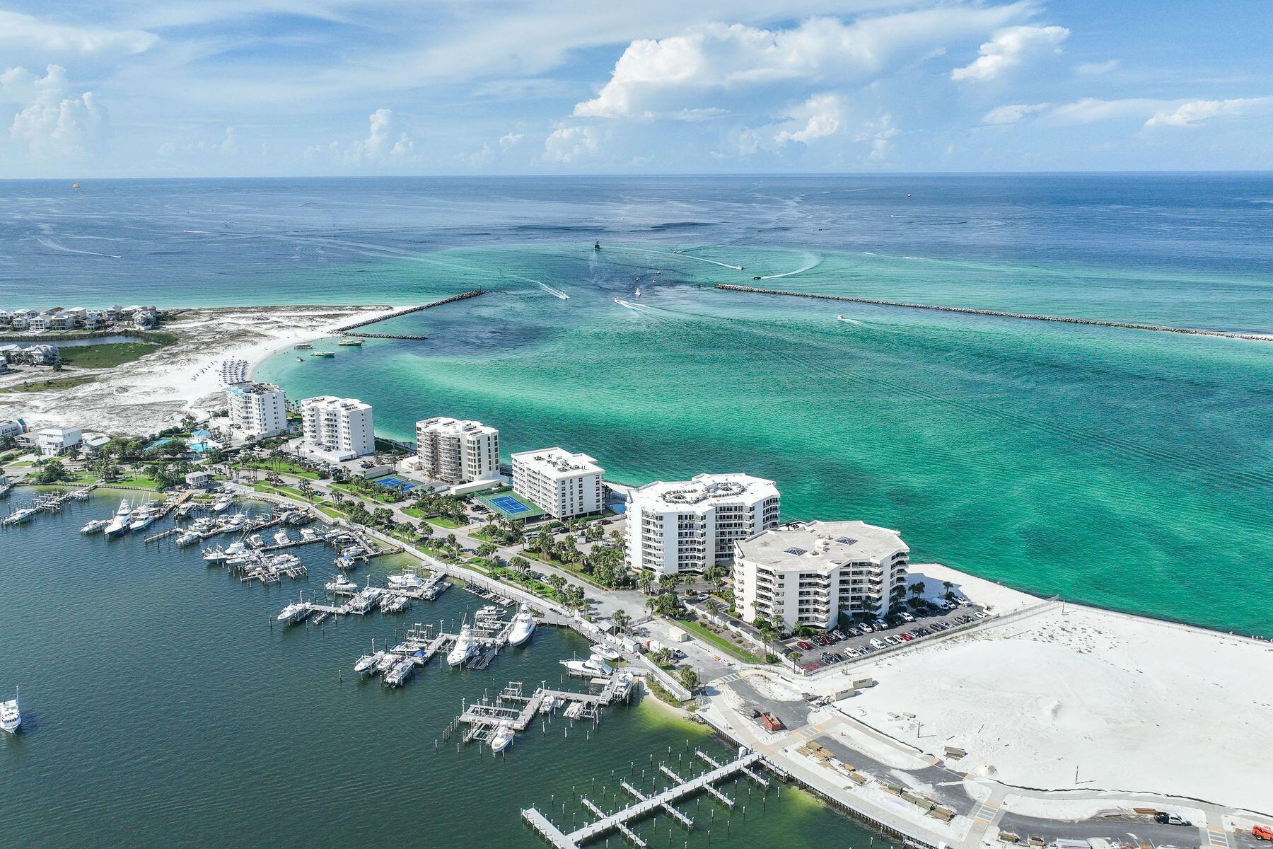 Three Month Minimum Rental Period. Dedicated Garage Parking Spot and Storage. SIRS complete and all assessments paid. Two Master Suites. Beach or boater's delight. Gulf, East Pass and harbor views. Fireworks, air shows and incredible night light views from an expansive balcony. Perched on the sixth floor at the very tip of Holiday Isle, this gracious residence offers panoramic views that sweep from the Destin Harbor to the sparkling gulf waters of the East Pass. Walls of floor-to-ceiling glass and a generous balcony that spans the full width of the unit invite both sunlight and sea breezes into nearly every corner, creating a serene waterfront sanctuary. The spacious layout unfolds with ease, offering a large living and dining area that is seamlessly connected to a well-appointed kitchen, complete with granite countertops, stainless steel appliances, a generous bar, stainless steel appliances, a generous bar, and a dedicated wine bar, all designed for effortless entertaining. Two private master suites, each with its own ensuite bath, provide luxurious accommodations for owners and guests alike, while a third bedroom and full bath offer additional flexibility. Resort-style amenities elevate everyday living, featuring an exclusive owners-only seasonally heated pool, hot tub, fitness center with sauna, a club room for events, as well as a private stretch of white-sand beach. A covered garage space right by the elevator entrance and dedicated storage room add convenience. A private marina just across the street offers deep-water boat slips for sale, for boaters who want to enjoy Destin's famed waterways. No boat, no worries, as you can call the boat taxi to pick you up at the East Pass Marina dock for quick trip across the water to award winning, boat-to-table seafood restaurants and night life on the harbor.  East Pass Towers II is a secure, gated building renowned for its quiet, residential atmosphere with a 3-month minimum rental period. Featuring thoughtful updates, the condo association has proactively nearly completed all needed maintenance and improvements and all assessments have been paid by the seller. From fireworks and air shows on summer nights to tranquil mornings watching boats or dolphins glide by, this is waterfront living at its finest. Destin Executive Airport is just 2.3 miles away for all the pilots wanting to escape the beach or if you prefer charter services. Next to East Pass Towers and nearing completion of improvements is Norriego Point Beach Access and Park where, according to the City of Destin website, will include ADA accessible restrooms, showers, drinking fountains, environmental educational signage, bike racks, boardwalk, dune crossovers, and vehicle parking.