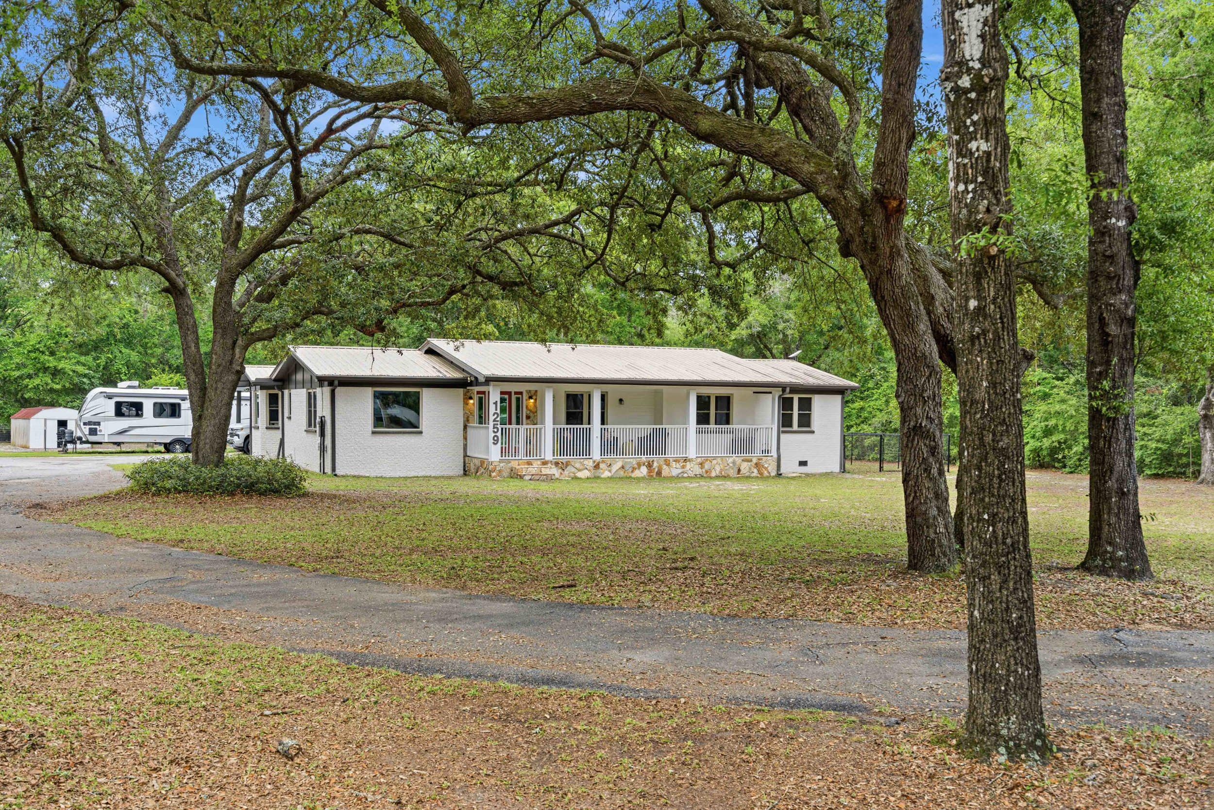 Step into a bright, split-layout ranch where the 2023 kitchen renovation sets the tone: granite counters, updated soft-close cabinetry, new appliances, and a pantry generous enough to mean something. Fresh paint and new LVP flooring carry a clean, cohesive warmth from room to room across all four bedrooms and two full baths.
Outside, a full acre unfolds with intention. The screened patio transitions into a spacious backyard -- private, quiet, and fully equipped with dual RV hookups (50 and 30 AMP), a 2-car carport, and two powered outbuildings ready for a workshop, studio, or overflow storage. A fenced chicken coop adds a functional, charming element rarely found at this price point.
Every major system has been addressed: 2025 water heater, 2024 doors, 2022 HVAC, 2018 roof and windows. One mile to Black Creek boat launch. 3.5 miles to Downtown Freeport. No HOA.
