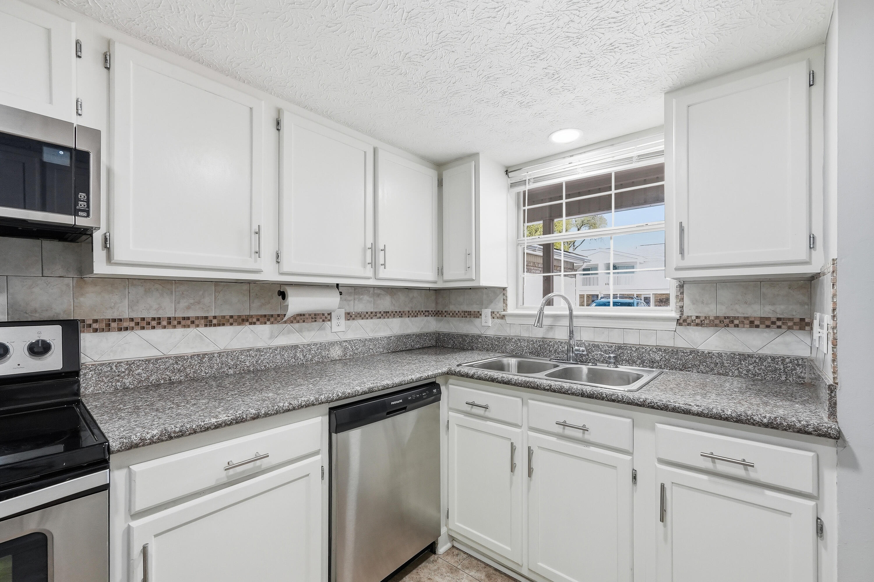 This updated two-story townhome in Fort Walton Beach checks every box for a smooth PCS landing. It's in move-in ready condition, there's no HOA, and it's an easy commute to Eglin AFB and Hurlburt Field. With a fully privacy-fenced backyard, attached garage, and a kitchen that's been almost completely rebuilt, this is the kind of home that takes the stress out of relocation.
Step inside to find neutral paint and beautiful tile floors throughout the entire home that's clean, low-maintenance, and ready for whatever a military move throws at you. The u-shaped kitchen just off the front entrance has many updates with stainless steel appliances, including a bottom-freezer refrigerator, new sink, and granite countertops.  A pantry adds extra storage, and the kitchen opens seamlessly into the combined dining and living area keeping guests and family connected.
A dedicated laundry room and convenient half bath round out the first floor. Head upstairs to find both bedrooms and the full bath. The spacious primary bedroom features a walk-in closet and a private door directly to the full bathroom which includes a tub/shower combo and single vanity. There's also a secondary hallway entrance for guests. The second bedroom is well-sized with a ceiling fan, and both rooms stay comfortable year-round with central electric heat and air.
Out back, a fully privacy-fenced yard gives you a secure outdoor space for pets, grilling, or just unwinding after a long day. The covered patio extends your living space outside. The attached garage fits one vehicle and the driveway accommodates two more, so parking is never an issue.
Tucked at the end of a low-traffic dead-end street in the Winterhaven subdivision, this townhome keeps your commute short while putting beaches, dining, and shopping within easy reach. No HOA means no extra fees eating into your BAH. Schedule your showing today to see this move-in ready townhome!