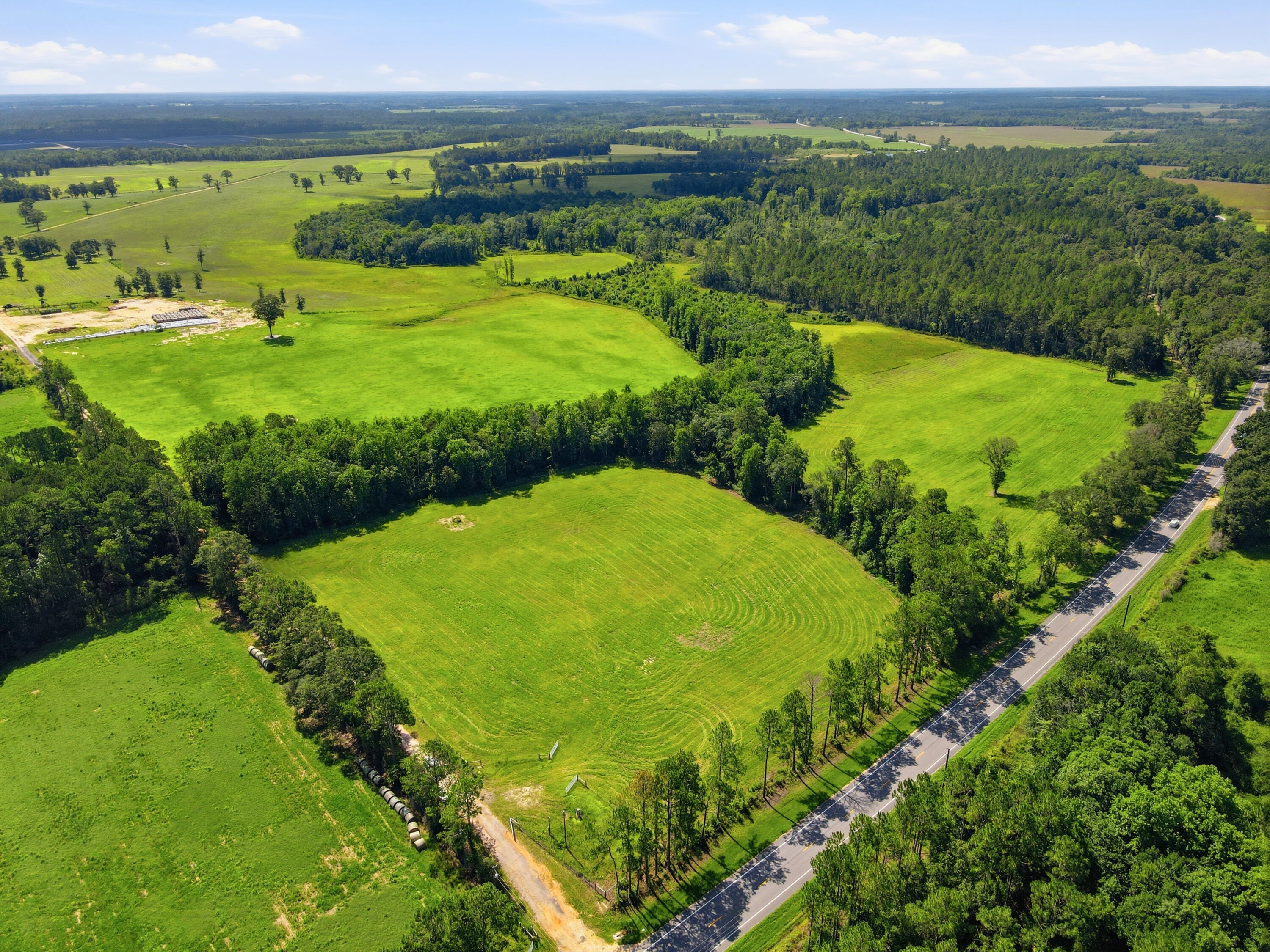 520± Acres -- Premier Cattle Ranch on US Hwy 331 N | Walton County, FL

A rare offering in the heart of the Florida Panhandle -- this 520-acre working cattle ranch combines productive, fully fenced and cross-fenced pasture with mature hardwood timber, offering both grazing capacity and natural cover for livestock. Direct frontage on US Hwy 331 N provides easy access while maintaining the privacy and scale of a true working ranch.
Property Highlights

520± total acres, predominantly open, improved pasture with rotational cross-fencing already in place for efficient herd management
Fenced and cross-fenced into multiple pastures with metal gates and working entrances throughout.
Rolling, well-drained topography with excellent grass coverage, visible mowing/hay patterns, and strong stands of improved Tifton 9 Bahia grass.
Fourteen watering stations located throughout the ranch fed by two wells.
Mature oak-lined lanes and shade trees scattered throughout the pastures -- ideal natural cover for cattle.
Hardwood and pine timber tracts border and bisect the pastures, offering wildlife habitat, wind protection, and a beautiful natural backdrop.
Creek/drainage bottoms with dense hardwood buffers running through portions of the property.
Established interior road and lane system connecting pastures for easy equipment and livestock access.
Direct paved frontage on US Hwy 331 N, offering convenient access for cattle trailers, feed delivery, and buyers. Currently operating as an active cattle ranch with herd on-site
Surrounded by a mix of agricultural and timberland, preserving the rural character of the area

Location
Situated along US Highway 331 N in Walton County, this property offers the balance of rural seclusion with reasonable proximity to Freeport, DeFuniak Springs, and the Gulf Coast beaches of South Walton -- making it attractive to both working cattle operations and buyers seeking a recreational/agricultural investment.
Ideal For

Established cattle operations looking to expand grazing capacity
Investors seeking agricultural land with long-term appreciation potential
Buyers wanting a large-acreage retreat with working ranch income potential
Hunting/recreational use given the mix of pasture and hardwood timber.