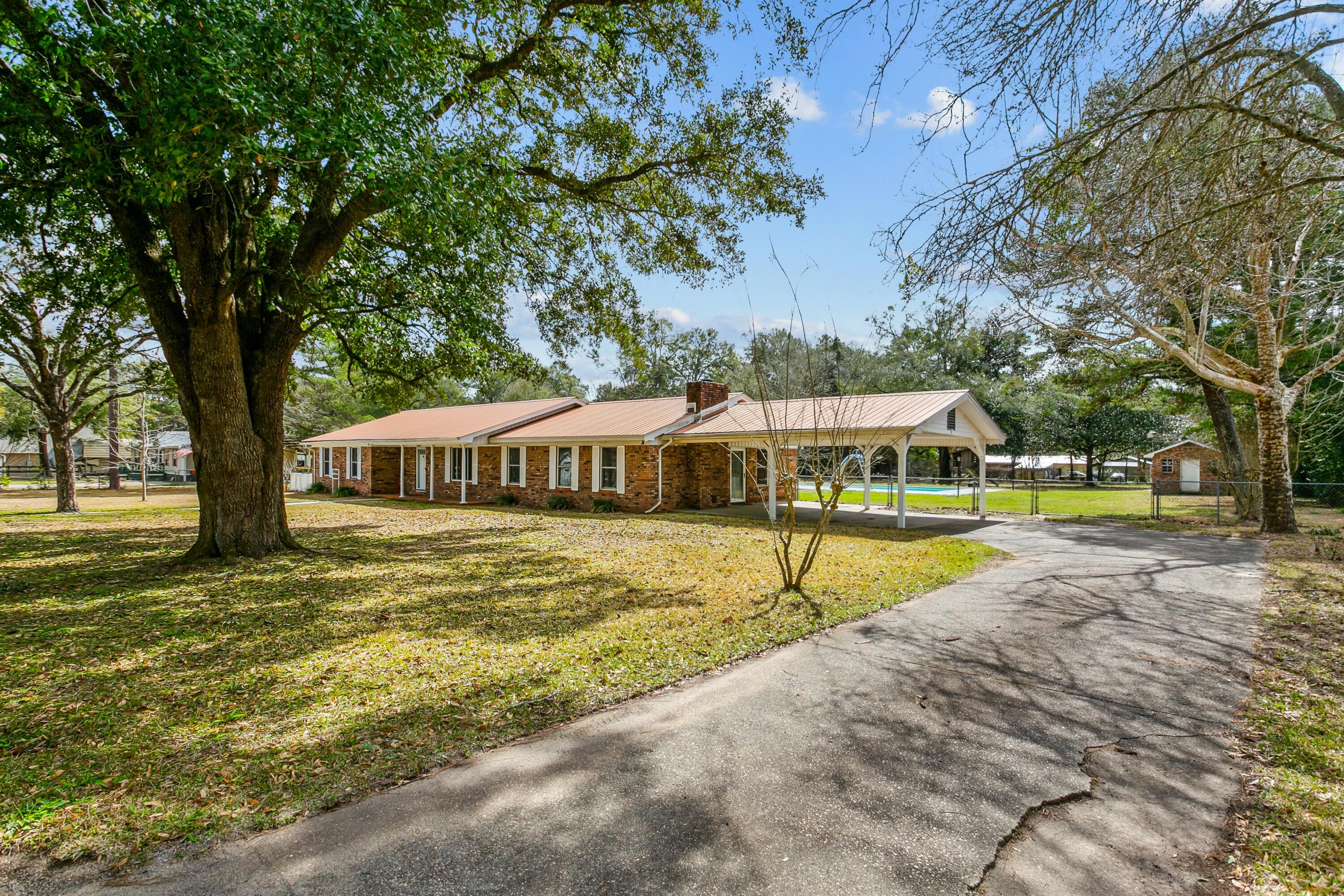 BRICK ESTATE with INGROUND POOL, on 1.5 ACRE LOT, featuring 24 X 32 POWERED WORKSHOP, COVERED RV PARKING & HOOKUP, MULTIPLE STORAGE BUILDINGS, VINEYARD, FRUIT TREES, SCREENED PORCH, BRAND NEW CHEF'S KITCHEN, 2 MASTER SUITES... and that's just the beginning of a LONG LIST OF UPGRADES!

They don't build them like this anymore!

Welcome to your custom masonry estate; featuring metal roof with expansive columned southern-style front porch, mature landscaped acreage, and entry pillars flanking a long driveway that will accommodate several cars.  

Step inside to a 4 BR/3 Bath PLUS BONUS ROOM that will accommodate large gatherings with space to spare.

(Continued)

 The grand formal living/dining space features stained crown molding, laminate wood flooring and large picture window overlooking mature trees.

The owners renovated the gourmet kitchen -- CUSTOM OAK CABINETRY, ELABORATE PANTRY SYSTEM, GRANITE ISLAND AND BREAKFAST BAR, DOUBLE OVEN WITH COOKTOP, glass tile backsplash... and eat-in breakfast area. BONUS: Your kitchen overlooks your inground pool. Details on the pool area momentarily.

The HUGE FAMILY ROOM also overlooks the pool and includes wood-burning fireplace with hearth and built-in wood storage. There's also a built-in wall storage for crafting or gaming. 

Let's talk master suites (there are two of them).

The first is spacious with 2 closets (1 walk-in), laminate wood flooring, picture window and a large master bath that offers corner jacuzzi, separate makeup vanity, 2 sinks, linen closet, separate shower with faux marble treatement and UNTAPPED EQUITY!

The second master suite is cozy, with views of the pool and a private bathroom that offers standard tub/shower combination. 

Bedroom #3 boasts a built-in wardrobe and Bedroom #4 touts two separate closets (one of them HUGE).

The owners renovated the 3rd bathroom adding a 2 person walk-in shower with glass doors, single vanity and new toilet. 

The bonus room would be perfect for an office, homeschool area or crafting room. #YouDecide 

Now for the backyard...

Not only do you have a SCREENED PATIO, you also have a COVERED PATIO.. and an OPEN PATIO FOR GRILLING! There's an INGROUND POOL WITH SLIDE and plenty of lounge space for tanning. 

The handyman or handywoman will appreciate the POWERED WORKSHOP WITH GARAGE DOOR AND SPACE FOR WOODWORKING, along with a separate TRACTOR LEAN-TO SHED. 

Guests will enjoy the COVERED RV PARKING PAD WITH HOOKUP.

Gardeners will relish the grape vineyard, fruit trees, gardens and multiple storage sheds found on the property (some of them insulated). 

Did I mention there is also a treehouse? This was a favorite feature for the owner's children and grandchildren. Many memories were made in the treehouse. 

The backyard is fully-fenced with worry-free hurricane fencing and includes multiple gates for access. The parklike setting also  includes a picnic table and firepit area for evening retreats under the stars.

This is one of the largest lots in this part of Crestview, and I am happy to report COUNTY TAXES and NO HOA! 

This estate hits all the checkboxes on your list.. YET YOU STILL HAVE UNTAPPED EQUITY! Are you ready to cash in?

Make an offer today!