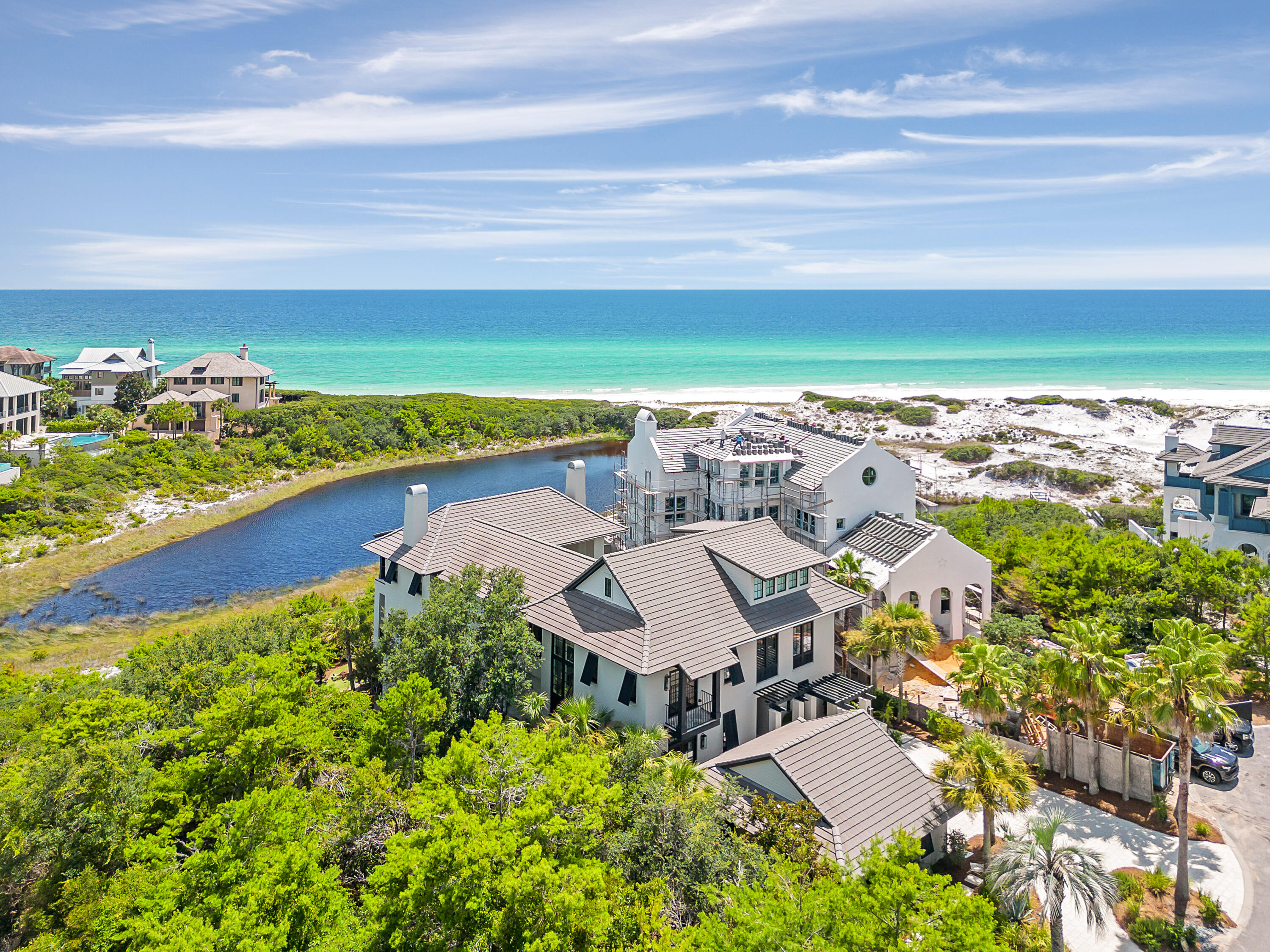 Palatial in scale and design, this six-bed, six-and-a-half-bath concrete constructed home boasts incredible lake and gulf views. Located in The Retreat, this distinguished home is privately situated behind wooden gates and has two large balconies for enjoying the mesmerizing gulf views. All three floors of luxury living can be accessed by an elevator. A sense of arrival is experience as one walks from the grand entryway to the great room, passing a formal dining room with a heavy wood-beamed ceiling. A wet bar is perfectly located for serving drinks when entertaining indoors or outside by the pool. Multiple windows look out onto the serene heated pool and terrace with amazing gulf and dune lake views from every angle. Steps add to the changing dynamics of the grand living space with multiple windows framing lake and gulf vistas. The spacious sitting room is carefully arranged around a chateau-sized fireplace with built-in display shelving on either side. French doors provide a seamless flow onto the generous wraparound terrace with a shady pergola for outdoor living. It's a place to linger and savor gentle gulf breezes and panoramic views. The fully equipped outdoor kitchen is perfect for casual dining and entertaining. An open fireplace adds warmth on cooler evenings. The restaurant-worthy chef's kitchen is magnificently appointed with custom cabinets and granite counters. A large island and a butler's pantry with a wine refrigerator provide additional workspace when entertaining. An impressive Wolf gas stove sits beneath a huge hood in an exquisitely tiled recess. All six bedrooms have their own private baths, featuring custom showers and cabinetry. In the first-floor guest suite, white oak floors resonate with white decor to create a serene ambiance. A sleek private bathroom and an oversized walk-in closet with built-ins complete this beautiful space. The signature staircase is furnished with decorative wrought iron banisters, adding to the timeless styling. A large landing provides an additional sitting area with a TV and wet bar. It's the perfect hub for guests to fix their own breakfast or morning coffee. Lit by a glittering chandelier, the primary bedroom outshines the rest with a fireplace, sitting area and a dressing room with built-ins. It has direct access to a private balcony overlooking the Draper Lake and the Gulf. The spa-like bathroom includes a deep soaking tub, a walk-in shower with a seat and a spacious twin vanity. The third floor is a self-contained den with built-in bunk beds, a wet bar and a sitting area. This exclusive home is completed with a sweeping driveway for parking, a two-car garage and camera security. Located in Blue Mountain Beach, The Retreat is a gated, non-rental community covering 90 acres with just 87 home sites. This exclusive oasis includes areas of conservation and a private white sandy beach on the Gulf of Mexico, with unparalleled amenities, including a newly revamped and private beach club, 1,000 feet of private beach and ongoing dune restoration efforts.