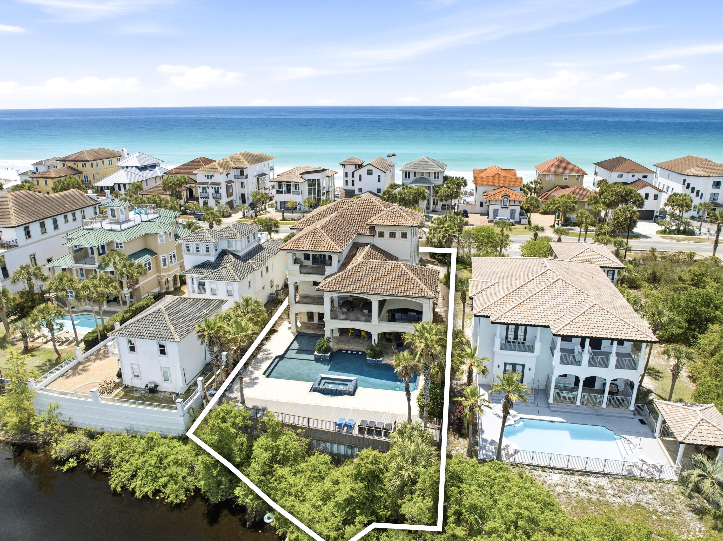 Welcome to an exceptional beachside retreat in the heart of Destin, where coastal luxury meets effortless income potential. Perfectly positioned with 61 feet of lake frontage and sweeping Gulf views, this remarkable residence is just steps from the sugar-white sands of the Gulf of Mexico and a short stroll to a sprawling beach access. The first level is designed for recreation and seamless indoor-outdoor living, featuring a spacious game room complete with a pool table, arcade games, and a convenient kitchenette with full-size refrigerator and ice maker. Multiple guest suites and bunk accommodations offer flexibility for large groups, while direct access leads to a true backyard oasis. The outdoor space lives like a private resort, highlighted by a beautifully designed pool with Baja shelf and spa, expansive sundeck, and tranquil lake views. A covered outdoor living area with a full kitchen, grill, beverage cooler, fireplace, and mounted TV creates the perfect setting for entertaining or unwinding after a day at the beach. A thoughtful feature includes an elevator servicing all three levels. The second level serves as the heart of the home, where an open-concept layout seamlessly connects the kitchen, dining, and living areas. A chef's kitchen anchored by an oversized island and premium appliances flows into a grand dining space accented with vaulted Pecky cypress ceilings and designer lighting, ideal for hosting large gatherings. The living room is filled with natural light and opens to a spacious balcony overlooking the pool and lake with direct access to the pool deck, adding convenience and extending the living space outdoors. Additional guest suites on this level provide comfort and privacy, with select rooms offering private balcony access. The third level offers a more private retreat with an additional living area and multiple well-appointed king suites, each with en suite baths. Select bedrooms feature soaking tubs and private balconies capturing glimpses of the Gulf, while additional bunk accommodations ensure ample space for guests. At the top, a rooftop viewing deck provides a breathtaking vantage point, where sunsets over the Gulf create an unforgettable daily experience. Offered fully furnished and turnkey, this expansive residence comfortably accommodates up to 28 guests and is ideally suited as both a legacy second home and a high-performing short-term rental. This is a rare opportunity to own a property that truly captures the essence of Destin living, blending scale, luxury, and an unbeatable location into one extraordinary offering.