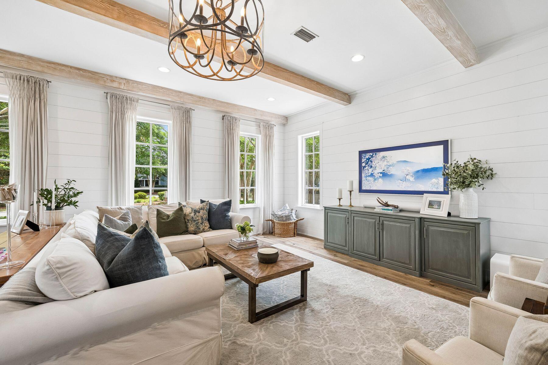Tucked away in the highly sought-after Carson Oaks community, this beautifully appointed 3-bedroom, 3-bathroom home offers 2,392 square feet of thoughtfully designed living space with exceptional indoor-outdoor living. Brimming with curb appeal, the home welcomes you with a paver driveway, expanded parking, charming red-brick entry, a screened porch, and a one-car garage. Backing to a peaceful common area and featuring a fenced backyard, the setting provides both privacy and picturesque surroundings. Inside, stunning finishes and abundant natural light create an inviting atmosphere throughout. A spacious screened porch extends the living space and serves as the perfect place for entertaining or relaxing year-round. The first floor features a generous living room highlighted by beamed ceilings, shiplap accents, and wide-plank flooring. The open-concept layout flows seamlessly into the dining area and designer kitchen, complete with quartz countertops, ceiling-height custom cabinetry with wine storage, KitchenAid appliances, an apron-front sink, under-cabinet lighting, and a elegant herringbone tile backsplash extending to the ceiling. Completing the first floor is a well-designed guest retreat featuring a spacious bedroom and full bathroom, along with a generously sized laundry room that adds everyday convenience. Upstairs, a secondary living area opens to an expansive covered porch, creating an additional retreat for family and guests. The primary suite is a true sanctuary, featuring elegant wainscoting details, direct porch access, and an ensuite bath with dual vanities and a walk-in shower. A generously sized third bedroom also enjoys porch access and a private ensuite bathroom. Carson Oaks is one of Santa Rosa Beach's most charming communities, known for its canopy of mature oak trees, lush landscaping, and welcoming entryway. Residents enjoy a community pool with restrooms, pickleball court, basketball hoop, and numerous green spaces. One of the neighborhood's most distinctive amenities is its waterfront recreation area, offering gated boat parking, paddleboard and kayak storage, a private boat launch, dock, covered gathering pavilion, and outdoor kitchen. Conveniently located just minutes from the shopping, dining, and entertainment of Grand Boulevard and the sugar-white sand beaches of South Walton, this exceptional home combines timeless character, modern luxury, and an unmatched coastal lifestyle.