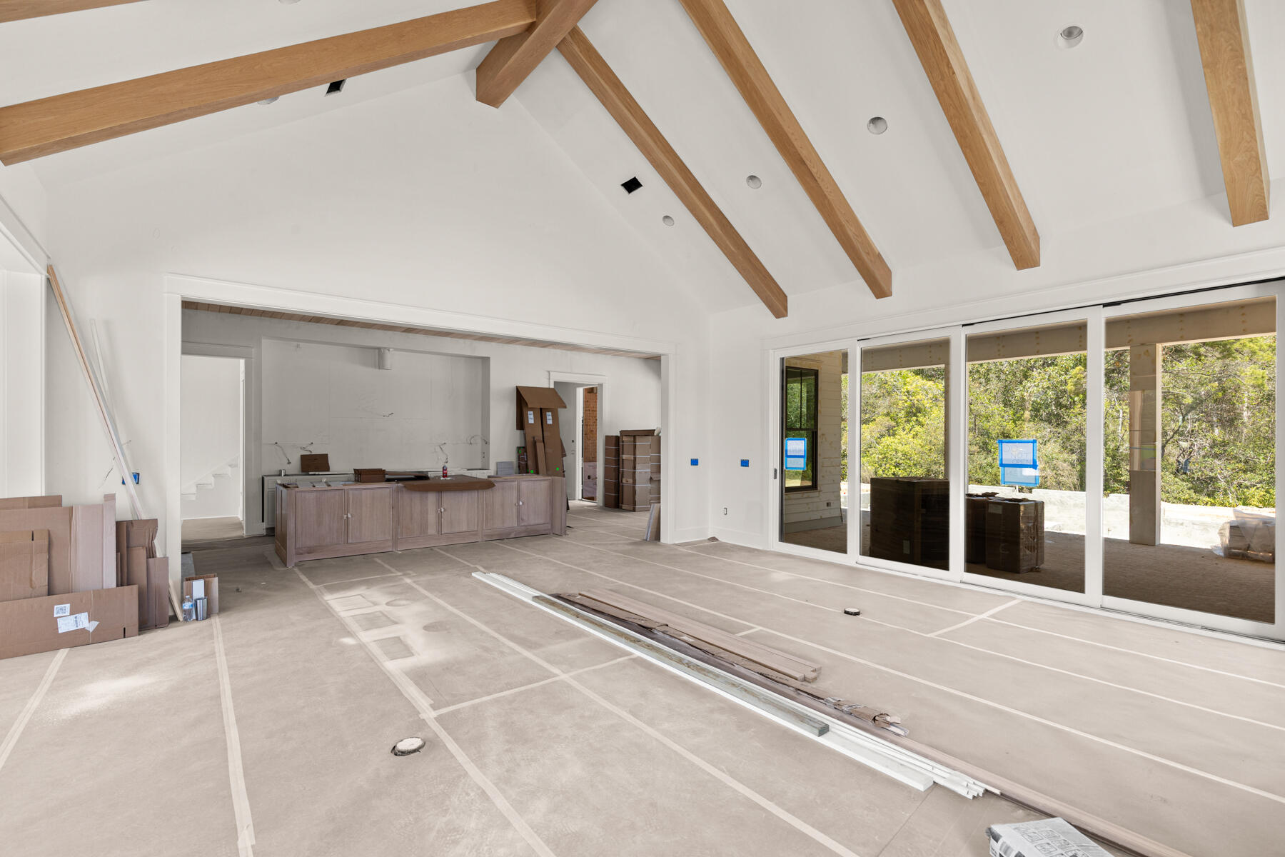 This custom residence by Huff Homes offers 4,200 square feet, 5 bedrooms, 5.5 bathrooms, and a 2-car garage with a dedicated golf cart bay, located on Homesite 55 in Powell Landing West at Watersound Origins. Set on a 140' deep homesite with a wooded backdrop and just steps from the community dock at Lake Powell, the property provides direct access to one of the area's defining natural features. Estimated completion is end of May '26.

The front elevation combines Nichiha siding with brick detailing, leading to a covered entry with brick flooring. Inside, the foyer opens to a central living area, with a private office just off the entry and a dining space positioned toward the rear The main living area is located at the back of the home, defined by vaulted ceilings with exposed wood beams and a wood-burning fireplace. A 16' sliding glass door extends the space to the rear porch, while the adjacent dining area features a 12' slider, creating multiple connections to the outdoor living areas.

The kitchen is centrally positioned between the living and dining areas, anchored by a large island and supported by a walk-in pantry and separate butler's pantry with wet bar. Integrated cabinetry conceals a full appliance suite including a dual fuel range, multiple refrigeration units, and additional beverage and ice storage.

The primary suite is located on the main level with direct access to the rear porch and includes a freestanding tub, walk-in shower, and built-in closet storage. Additional first-floor bedrooms are positioned toward the front, while the laundry and mudroom connect to the garage and golf cart bay for everyday functionality.

As you ascend the stairs, detailed with iron handrails, white oak posts, and integrated stair lighting, three additional bedrooms are arranged around a central sitting room. Ceiling heights of 11' on the first floor and 10' on the second floor maintain consistent volume throughout.

Outdoor living is centered around a 30' x 12' pool with a spa, screened porch with roll-screens , summer kitchen, and fireplace extending the living space and taking advantage of the depth of the homesite.

Additional features include wide-plank wood flooring, white oak interior doors, crown molding throughout, upgraded fixtures, whole-home dehumidification, a conditioned garage space, and epoxy-coated garage flooring.

Located within Powell Landing West, this home offers immediate access to Lake Powell, the community dock, and Watersound Origins amenities including trails, Village Commons, and the Origins Golf Course.