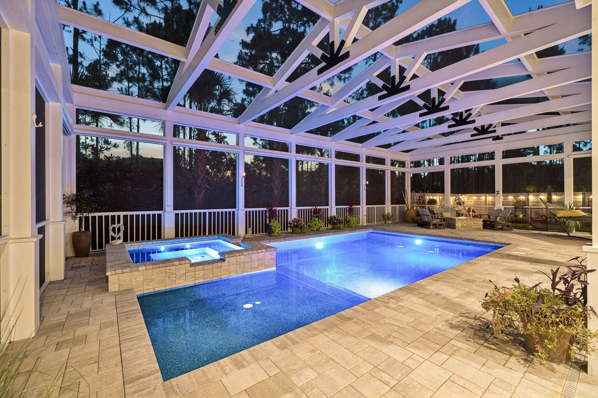 Tucked behind the gates of Seclusion Bay, this 2023 custom-built estate blends refined craftsmanship with the relaxed luxury of life along 30A. Set on a beautifully landscaped homesite framed by towering pines, this 5-bedroom, 4-bath home offers 3,866 square feet of thoughtfully designed living space, plus more than $300,000 in owner upgrades since purchase. Inside, light oak flooring and abundant natural light set a warm, elevated tone. The chef's kitchen features crisp white shaker cabinetry, quartz countertops, a designer tile backsplash, and a professional gas range with pot filler. Spacious bedrooms and spa-inspired baths deliver comfort at every turn. Beyond the five bedrooms, the home offers exceptional bonus living space upstairs - a generous bonus room, a cozy loft, and a mini kitchen with refrigerator, perfect for a secondary family room, game room, or entertaining retreat. Outdoor living is exceptional. A screened, paver-deck pool with brand-new Hayward heater (2025) and app-controlled lighting anchors the resort-style backyard. A newly built fence creates multiple private outdoor spaces, surrounded by extensive custom landscaping, crushed Bahama-rock seating areas, and pre-wired pads for waterfalls and lighting. A monitored security system and pre-wired infrastructure for security cameras round out the upgrades. Residents enjoy gated privacy plus a private community dock, ideal for boating, paddleboarding, and sunset gatherings on the bay. Best of all, the home sits just minutes from the beaches, dining, and boutiques of Scenic 30A. Schedule your private tour today.
