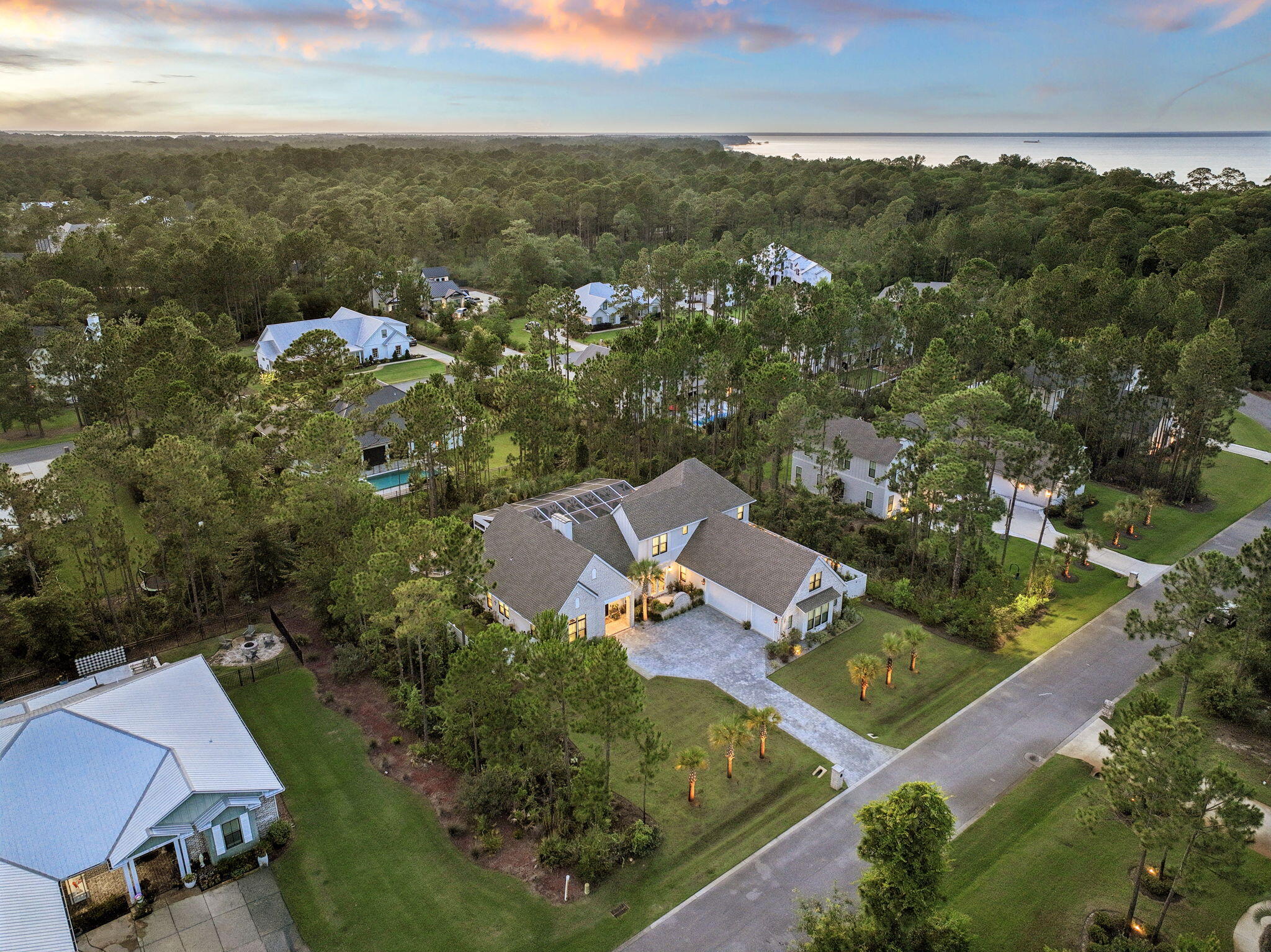 Tucked behind the gates of Seclusion Bay, this 2023 custom-built estate blends refined craftsmanship with the relaxed luxury of life along 30A. Set on a beautifully landscaped homesite framed by towering pines, this 5-bedroom, 4-bath home offers 3,866 square feet of thoughtfully designed living space, plus more than $300,000 in owner upgrades since purchase. Inside, light oak flooring and abundant natural light set a warm, elevated tone. The chef's kitchen features crisp white shaker cabinetry, quartz countertops, a designer tile backsplash, and a professional gas range with pot filler. Spacious bedrooms and spa-inspired baths deliver comfort at every turn. Beyond the five bedrooms, the home offers exceptional bonus living space upstairs - a generous bonus room, a cozy loft, and a mini kitchen with refrigerator, perfect for a secondary family room, game room, or entertaining retreat. Outdoor living is exceptional. A screened, paver-deck pool with brand-new Hayward heater (2025) and app-controlled lighting anchors the resort-style backyard. A newly built fence creates multiple private outdoor spaces, surrounded by extensive custom landscaping, crushed Bahama-rock seating areas, and pre-wired pads for waterfalls and lighting. A monitored security system and pre-wired infrastructure for security cameras round out the upgrades. Residents enjoy gated privacy plus a private community dock, ideal for boating, paddleboarding, and sunset gatherings on the bay. Best of all, the home sits just minutes from the beaches, dining, and boutiques of Scenic 30A. Schedule your private tour today.