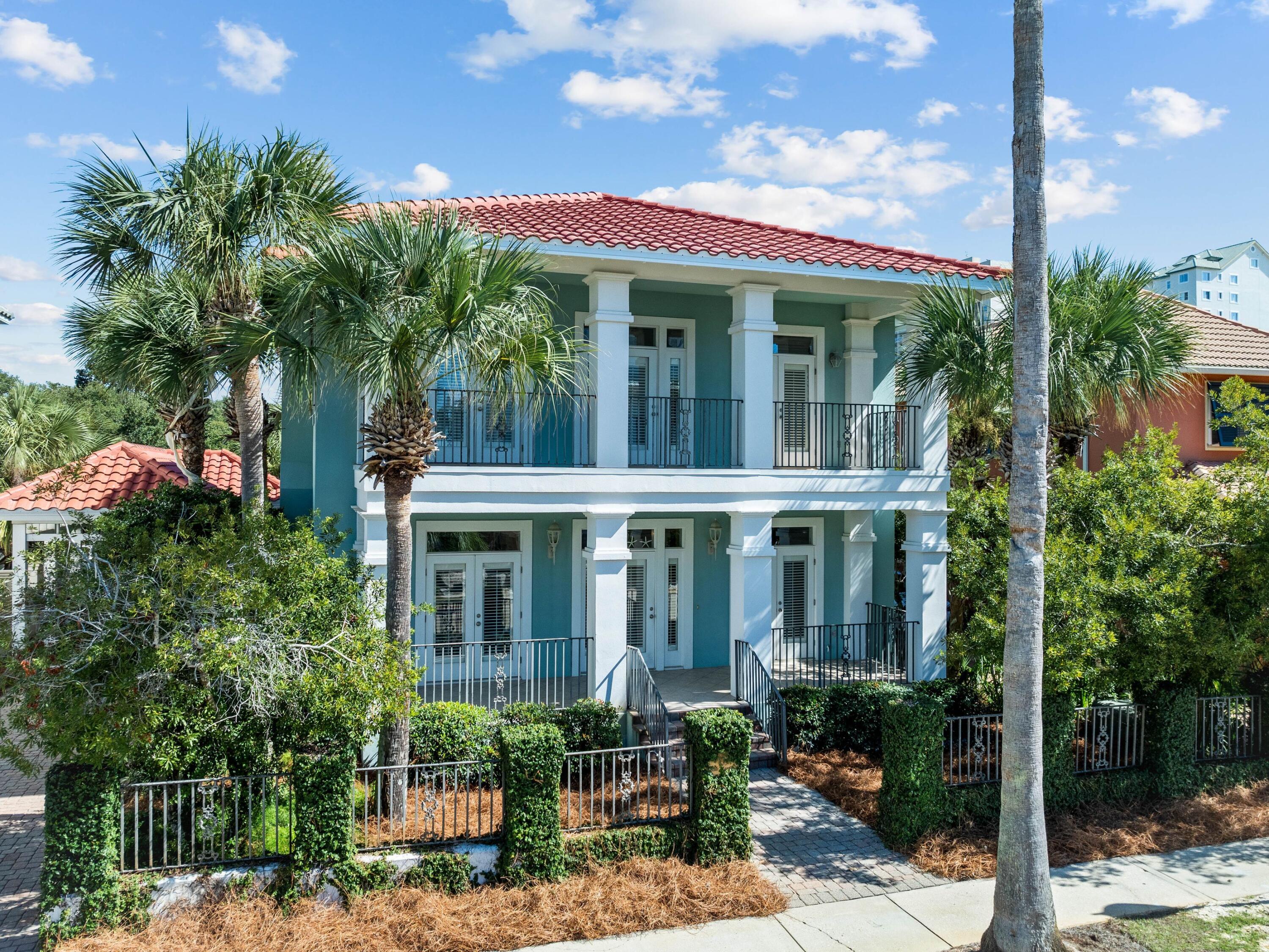 Life near the shoreline takes on a relaxed rhythm in this Caribbean-style coastal home located just a short walk from the beach. Positioned south of Highway 98 inside a guard-gated community, the residence offers a combination of privacy, character, and proximity to the water that is increasingly difficult to find. A landscaped and fenced front yard creates a welcoming approach, where a spacious covered porch introduces the home's breezy architectural style. French doors spanning the front of the living area allow sunlight to fill the interior while encouraging easy indoor-outdoor living.

The main level is designed for connection and comfort, with open living and dining areas flowing naturally into the kitchen. Architectural columns subtly define the spaces while maintaining a sense o openness throughout the floor plan. Plantation shutters, crown molding, and neutral coastal finishes contribute to the home's timeless aesthetic, while tile flooring across the first floor offers durability and easy maintenance after long days at the beach. A gas fireplace with a living flame effect creates a warm focal point in the living room and adds ambiance for evenings spent relaxing or entertaining guests.

The kitchen was updated in 2022 and combines practical design with coastal charm. A large center island provides generous prep space and features a glass cooktop with a stainless vent hood above. The farmhouse sink, stainless appliances, and marbled countertops create a bright workspace, while the breakfast bar peninsula offers a convenient spot for casual meals or conversation while cooking. The renovation included new cabinetry, countertops, stove, dishwasher, sink, disposal, washer, and dryer, giving the space a refreshed and modern feel.

Upstairs, hardwood floors extend throughout the bedrooms, adding warmth and continuity to the second level. The primary suite offers a peaceful retreat with access to its own private balcony. The ensuite bath features shiplap walls, a double vanity, and a whirlpool soaking tub designed for relaxing after a day spent by the water. A full-width covered porch spans the second floor, offering another comfortable outdoor space for morning coffee, reading, or enjoying the gulf breeze in the evening.

Behind the home, an elevated deck and shaded arbor provide an ideal setting for outdoor gatherings, weekend grilling, or quiet afternoons spent outdoors. With private beach access located just yards away, trips to the sand and water become part of everyday life.

Additional highlights include a covered carport with paved driveway parking, a tankless water heater, and a new roof installed in September 2024. Residents enjoy access to community amenities, including two pools, tennis courts, private beach access, and security within the gated neighborhood.

Short-term rentals are permitted with a seven-night minimum, creating an opportunity for both personal enjoyment and potential rental income. With its beachside location, recent improvements, and inviting coastal design, this home offers an exceptional opportunity to enjoy life close to the water.
OPEN HOUSE SATURDAY 3/28 1p-3p.
