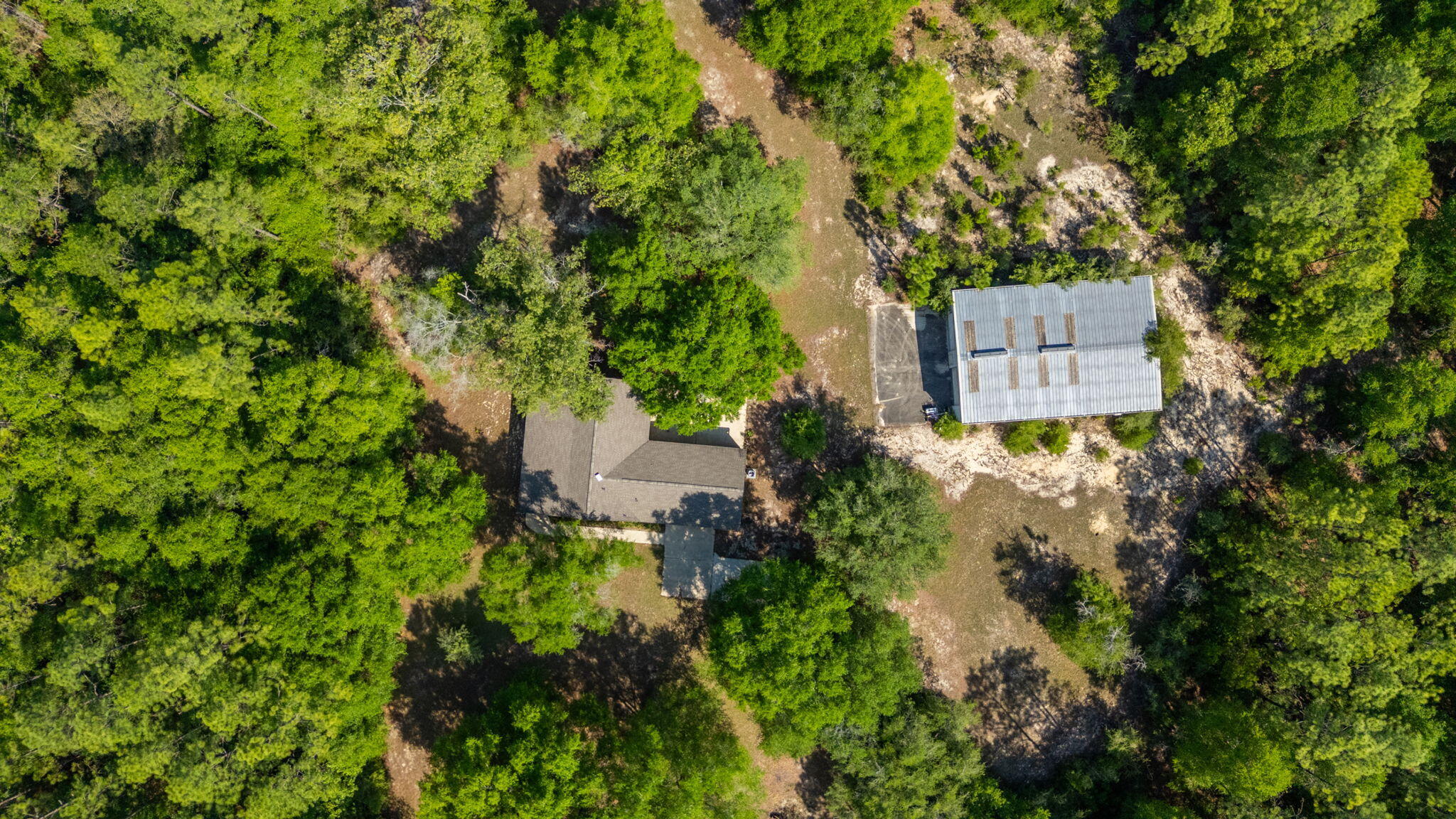 Tucked away this one-of-a-kind country property offers the kind of privacy that's hard to find and impossible to forget. Surrounded by over 6 acres with no neighbors in sight, this full brick home was built for those who appreciate air, privacy, and room to truly live. Inside, the thoughtfully designed split floor-plan offers 3 bedrooms and 2 baths with a comfortable, flowing layout. Wide front porch, perfect for rockers opens to the living area centering around a wood-burning fireplace, creating the perfect place to gather on cool evenings, while the kitchen opens seamlessly into the dining room. Durable flooring throughout means there's not a stitch of carpet anywhere in the home.What truly sets this property apart is the incredible amount of garage and workshop space. With approximately 2,800 square feet dedicated to storage, hobbies and equipment, the possibilities are endless.The oversized attached garage offers nearly 3-car capacity, while the impressive 40x60 detached shop with two roll-up doors and a concrete floor is ready for everything from classic cars and tractors to woodworking, welding, or recreational toys. Attached garage boasts utility sink. Separate electrical panels run the external garage.  Wired for generator. Home is on deep water well. 
Roof is 2020
HVAC is 2018 The oversized attached garage offers nearly 3-car capacity, while the impressive 40x60 detached shop with two roll-up doors and a concrete floor is ready for everything from classic cars and tractors to woodworking, welding, or recreational toys. Attached garage boasts utility sink. Separate electrical panels run the external garage.
Roof is 2020
HVAC is 2018