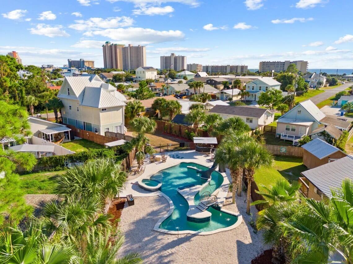 Rare and exceptional investment opportunity located on the East End of Panama City Beach in the desirable South Lagoon area. This 4-bedroom, 3.5-bath, 2,500+ sq ft home is being sold fully furnished and turnkey, with NO HOA and NO rental restrictions.
Situated on TWO lots just a few short blocks from beach access, this 3 story home is designed to maximize both guest experience and income potential. The first floor features a large game room with a pool table, TV and other games, while the main living areas offer ample space, perfect for entertainment and large groups. Step outside and you'll find what truly sets this property apart! The outdoor space is one of a kind featuring a heated custom lagoon style pool with a lazy river, swim up bar, waterslide, and jacuzzi.... all in the shape of a fish. Yes, a fish. Its the kind of feature guests talk about and rebook for. Add in the tiki bar, grilling area, and expansive outdoor space, and you have a private resort right in your back yard. The rear lot is gated and offers road access with a separate entrance, providing ample space for your boat, RV, or jet ski storage. Conveniently located near the public boat ramp with Gulf access, making trips to Shell Island quick and easy. With NO restrictions, the possibilities are endless. Properties with this level of amenities, lot size, and flexibility are extremely rare. This is more than home, its an experience and you don't want to miss out on it!