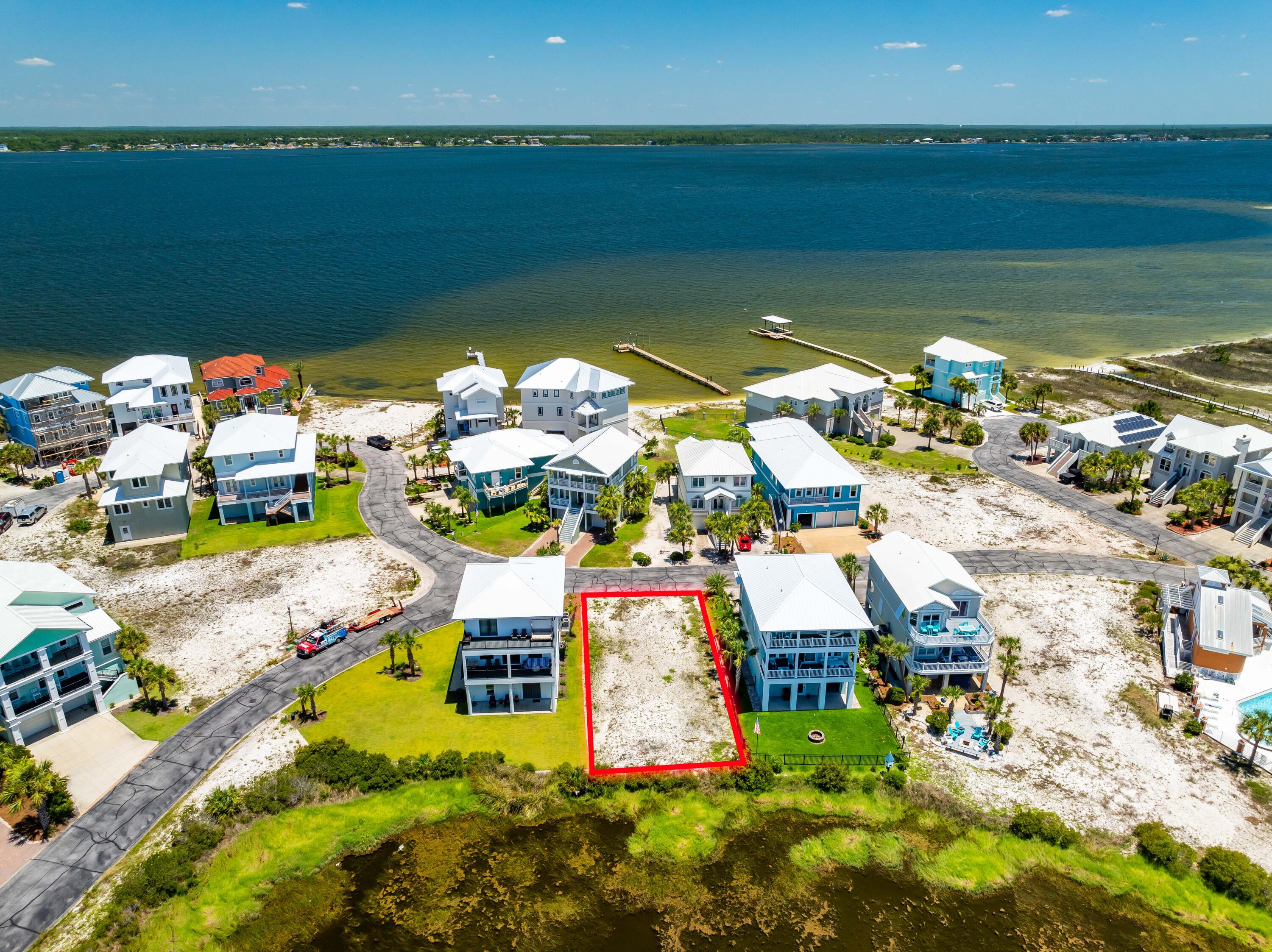 Large 50' x 99' Lot Bordering a Natural Pond within tranquil Gated Community of Caribbean Isle. Lot 4 Blk C is One of only five lots that it Backs Up to a Community Pond Area within the community ensuring no one can build directly behind you. This fantastic feature guarantees privacy and peace while highlighting the area's natural beauty. Experience the serenity of being surrounded by nature, yet remain part of a vibrant and desirable community. The lot also offer potential Santa Rosa Sound and Gulf Views for your future home. 
Caribbean Isle offers a variety of amenities for residents & guests to enjoy, including tennis courts, a gated entrance for added privacy and a sparkling community hot tub + swimming pool...it is Florida after all! Navarre Beach is one of the last areas with an ..