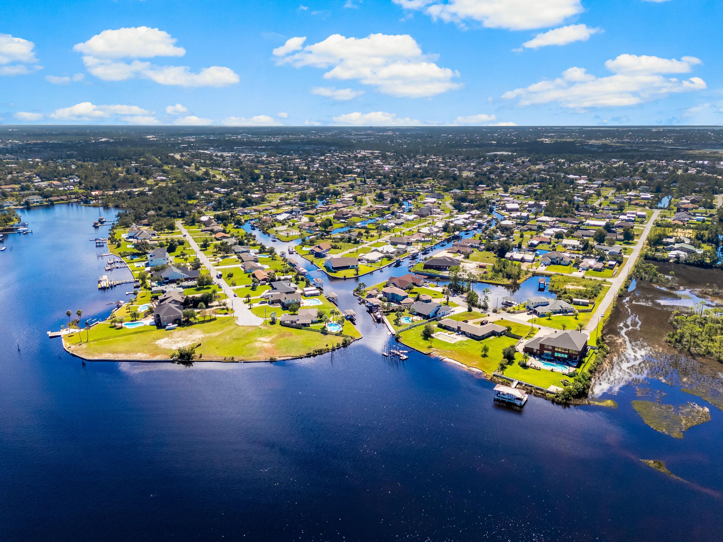 Positioned along a deep-water canal on a quiet dead-end, oak-canopied street, 4439 Vista Lane offers a relaxed waterfront setting designed for both everyday comfort and life on the water. Located in the desirable Northshore area of Lynn Haven, free from HOA restrictions, this three-bedroom, two-bath residence spans approximately 2,505 square feet and offers generous interior living space with direct boating access. The home's canal frontage is a defining feature, allowing you to step outside and head straight onto the water. A seawall replaced in 2022 and boat lift motors newly installed in 2025 within a covered boathouse enhance the property's functionality, making it easy to launch a boat and spend the day exploring the surrounding waterways, cruising toward Shell Island, or venturing out into the Gulf. The peaceful canal setting also creates an inviting backdrop for outdoor relaxation, whether enjoying morning coffee by the water or unwinding in the evening with a coastal breeze. A fully fenced backyard adds both privacy and practicality, ideal for pets, gatherings, or simply enjoying the outdoor space. Inside, the residence offers a spacious layout with flexible living areas suited for both quiet evenings and lively gatherings. Multiple living spaces allow for comfortable day-to-day living while providing room to entertain family and friends. Large windows invite natural light throughout the interior, reinforcing the home's open and airy atmosphere. Several major system improvements add long-term confidence for the next owner. The roof and windows were replaced in 2019, while essential infrastructure, including the septic tank, drain field, lift station, and well, was updated in 2016. These thoughtful updates enhance the home's functionality and durability while supporting a low-maintenance waterfront lifestyle. The property's location further enhances its appeal. Set within the established Northshore area of Lynn Haven, the home enjoys a sense of privacy while remaining close to everyday conveniences, top-ranking schools, local dining, and shopping. Lynn Haven itself is one of the most sought-after residential communities in Bay County, valued for its strong sense of community, parks, and access to the water. From this location, residents are just a short drive from the white sand beaches of Panama City Beach while still enjoying the quieter pace of a residential coastal town. With nearby marinas, boat ramps, restaurants, and retail centers, the area offers an ideal balance between waterfront recreation and everyday convenience.