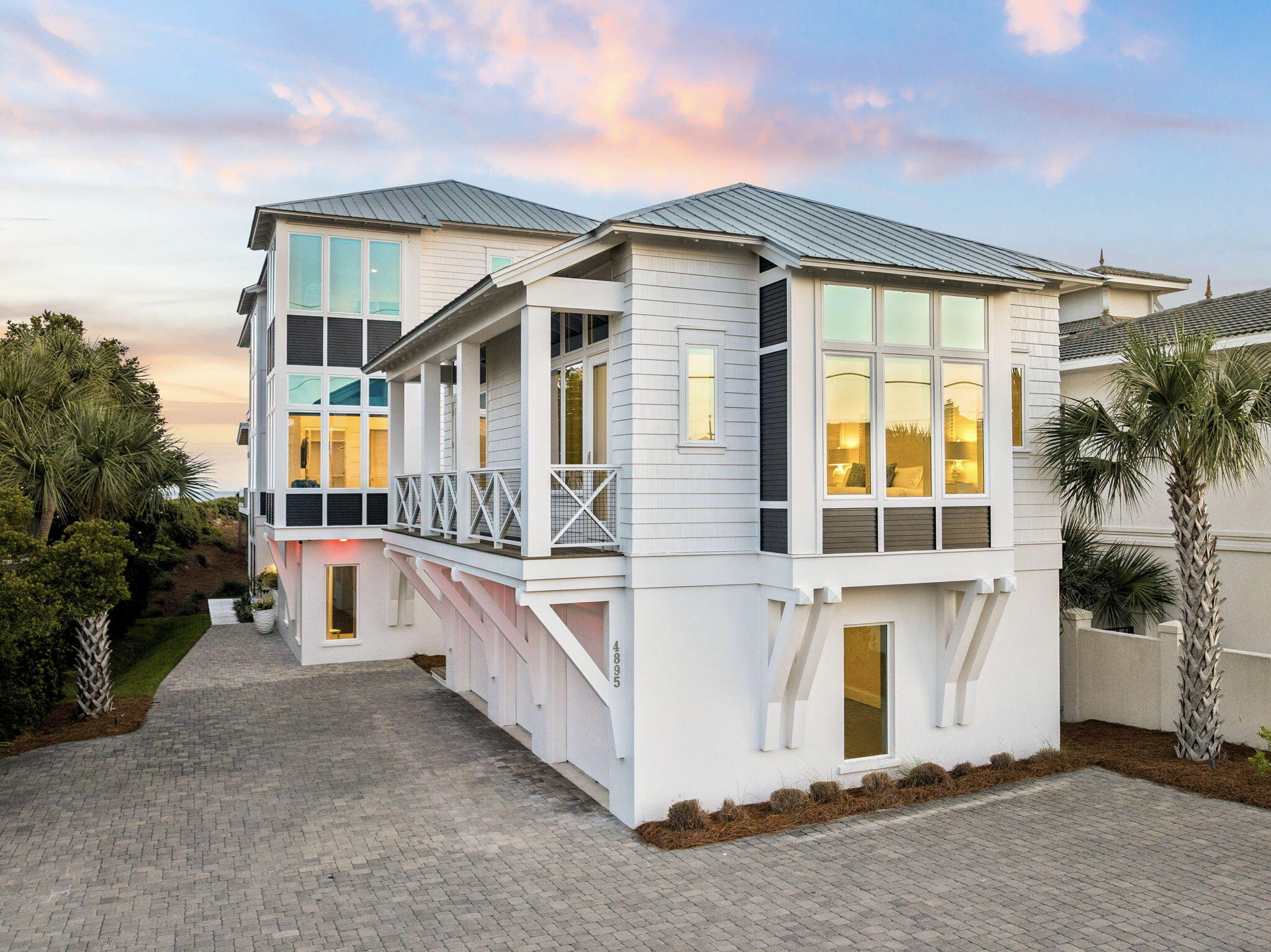 Set along the coveted west end of Scenic Highway 30A, 4895 W County Highway 30A is an extraordinary Gulf-front estate offering the perfect blend of luxury, comfort, and breathtaking coastal beauty. Built in 2020 and situated on a .39-acre homesite, this remarkable residence encompasses 6,751 square feet with six bedrooms, seven bathrooms, and unobstructed Gulf views from multiple levels.
Thoughtfully designed by Stackable Mracek Design Group for both entertaining and everyday living, the home features expansive gathering spaces, soaring whitewashed ceilings, designer lighting, and walls of glass that frame the emerald waters beyond. Full-height glass doors along the main living level create a seamless connection to the outdoor living spaces, while the third-floor primary suite enjoys its own stunning Gulf-front perspective.
The gourmet kitchen is equipped with premium Thermador appliances, custom cabinetry, a butler's pantry, and a stylish wine and bourbon nook. Additional features include two spacious bunk rooms, two laundry rooms, an indoor gas fireplace, and a private elevator servicing all three levels.
Outdoor living is equally impressive, with a heated pool, expansive terrace space, and a fully equipped outdoor kitchen featuring stainless steel appliances and a granite bar area. A rare opportunity to own a premier Gulf-front property on Scenic 30A, where exceptional design, privacy, and 61 feet of beachfront combine to create an unparalleled coastal retreat.