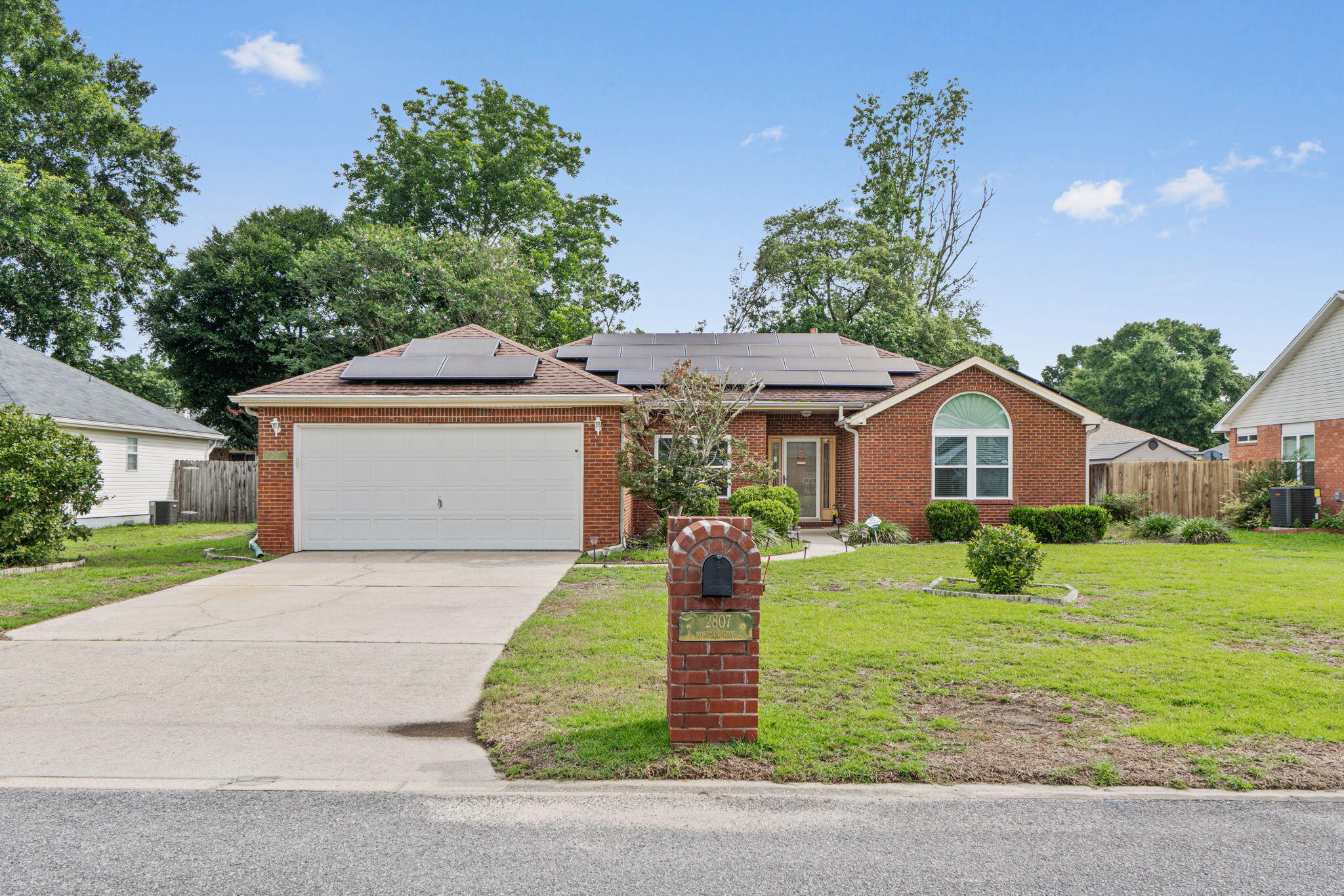 Welcome to this beautifully maintained 3-bedroom, 2-bath home in highly desirable South Crestview! Featuring a classic brick exterior and owned solar panels for added energy efficiency, this home offers the perfect blend of comfort and style. Inside, soaring cathedral ceilings create an open, airy feel, while a cozy corner fireplace anchors the spacious living room. Beautiful laminate wood flooring flows throughout the main living areas, with tile in the kitchen and bathrooms. The living room features tiled carpet installed over the laminate flooring for added comfort and can be easily removed. The spacious kitchen offers abundant cabinetry, generous counter space, and a breakfast bar that opens to the living area, making it ideal for everyday living and entertaining. The oversized primary suite provides a relaxing retreat, while two additional bedrooms offer flexibility for family, guests, or a home office. Enjoy year-round outdoor living in the large screened-in sunroom overlooking the fully fenced backyard--perfect for morning coffee or evening gatherings. A two-car garage, mature landscaping, and convenient access to military bases, shopping, dining, and the Emerald Coast's white-sand beaches complete this exceptional property. Schedule your private showing today!