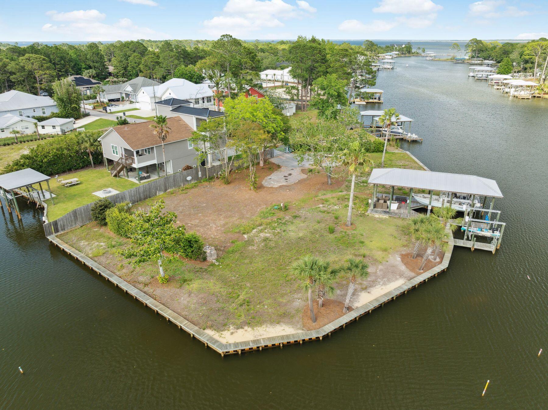 Nestled along the tranquil shores and deep waters of Buck Bayou in the heart of Santa Rosa Beach, this exceptional half-acre lot offers the perfect blend of privacy and access to the vibrant coastal lifestyle with a generously-sized boat slip measuring up to 52 feet. With approximately 330 feet of pristine water frontage entirely bordered by a seawall, this property boasts panoramic bayou views, setting the stage for stunning sunsets and serene water vistas. Water enthusiasts will appreciate the expansive dock, complete with a boathouse and two boat lifts, providing direct access to the bay and beyond. This protected bayou location ensures calm waters for boating, paddleboarding, and kayaking, while still offering the potential for sweeping water views from a future residence.